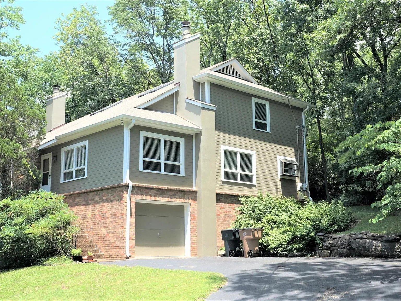 Two-story Nashville home with brick and siding exterior, attached garage, and wooded lot..webp