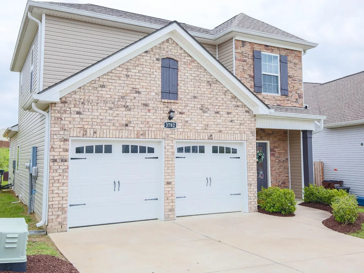 Two-story suburban Nashville home with brick and siding exterior, double garage, and neatly landscaped front yard..webp