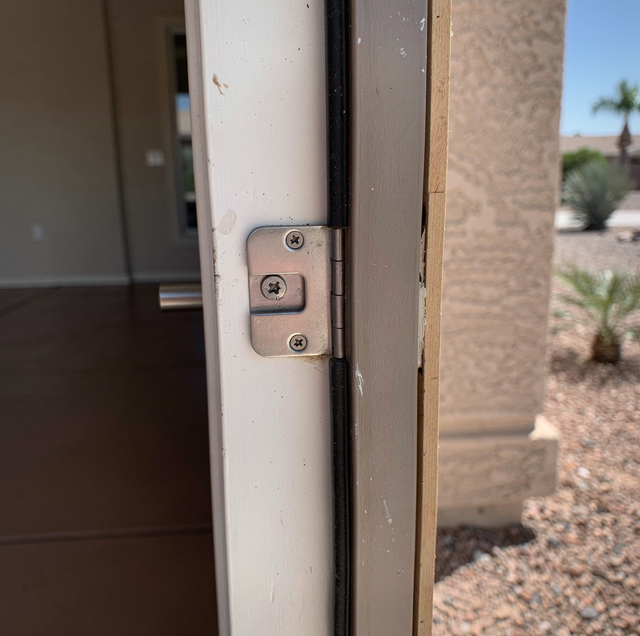 Front door latch bolt resting against metal strike plate