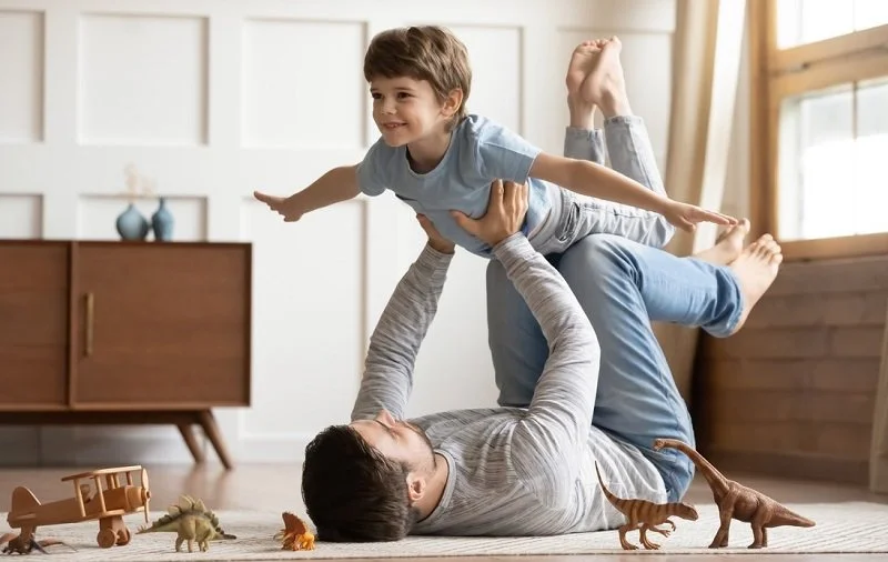 Parent lifting a child during playful movement.