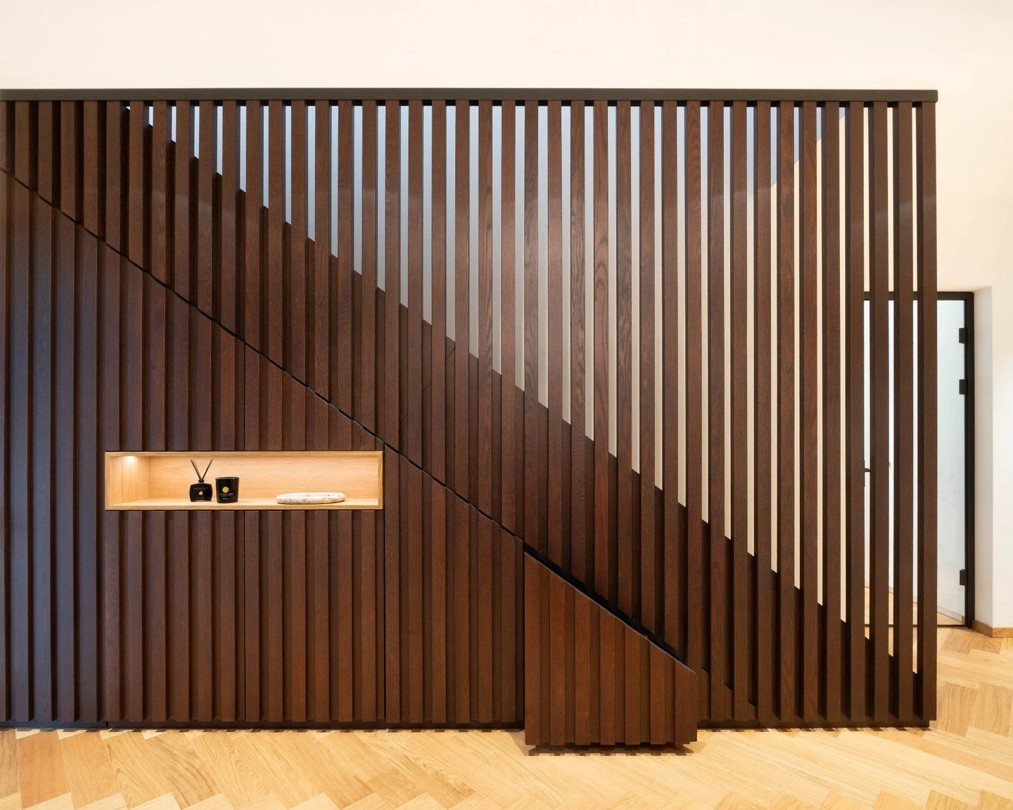 Treppenverkleidung aus massiver Eiche. Das Material wurde dunkel gebeizt und anschlie&szlig;end klar lackiert. Aus einzelnen Leisten haben wir diesen Treppenschrank passgenau integriert und das Design als Raumelement und Treppenabgrenzung weiter gef&