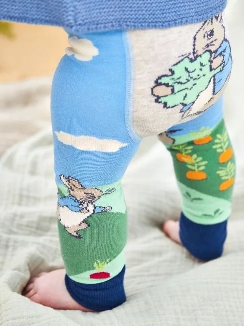 Knitted baby leggings with intarsia design of peter rabbit in an outdoor scene
