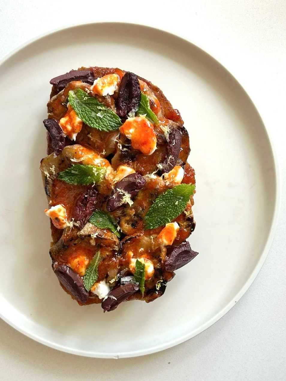 Evan hizo una tostada especial! Disponible ya! Berenjena, hot honey con aj&iacute; dulce, queso de cabra, kalamata olives, menta.