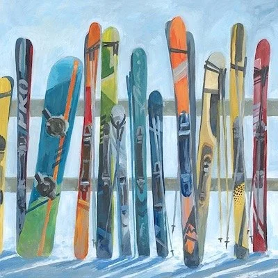 A row of colorful skis standing upright in the snow against a light blue sky.