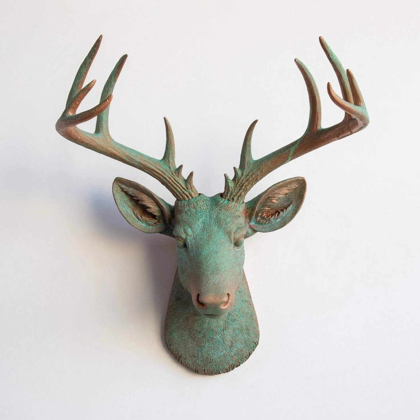 Metallic deer head sculpture with prominent antlers against a plain white background.