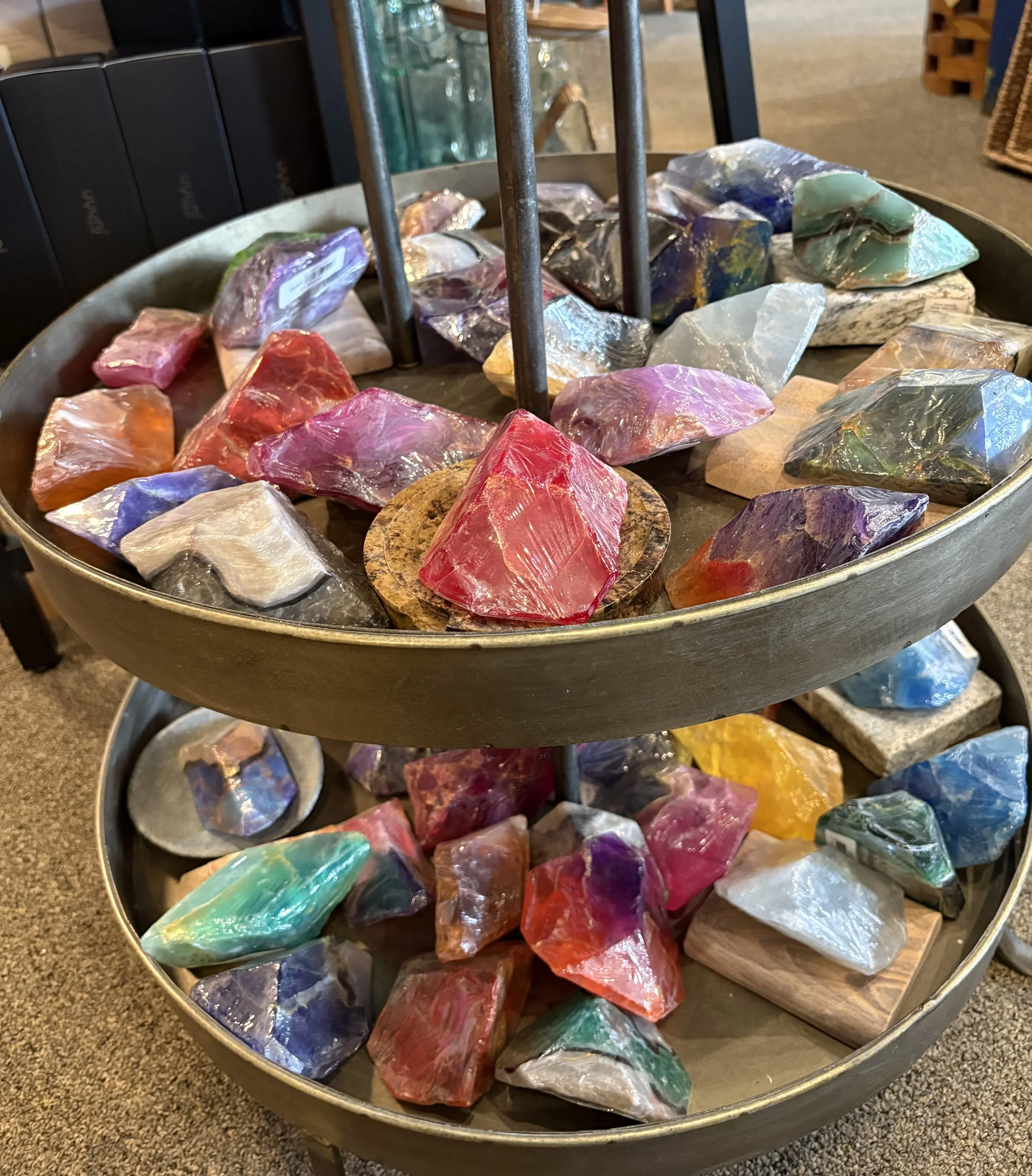 Colorful polished gemstones on a round display stand in a store.