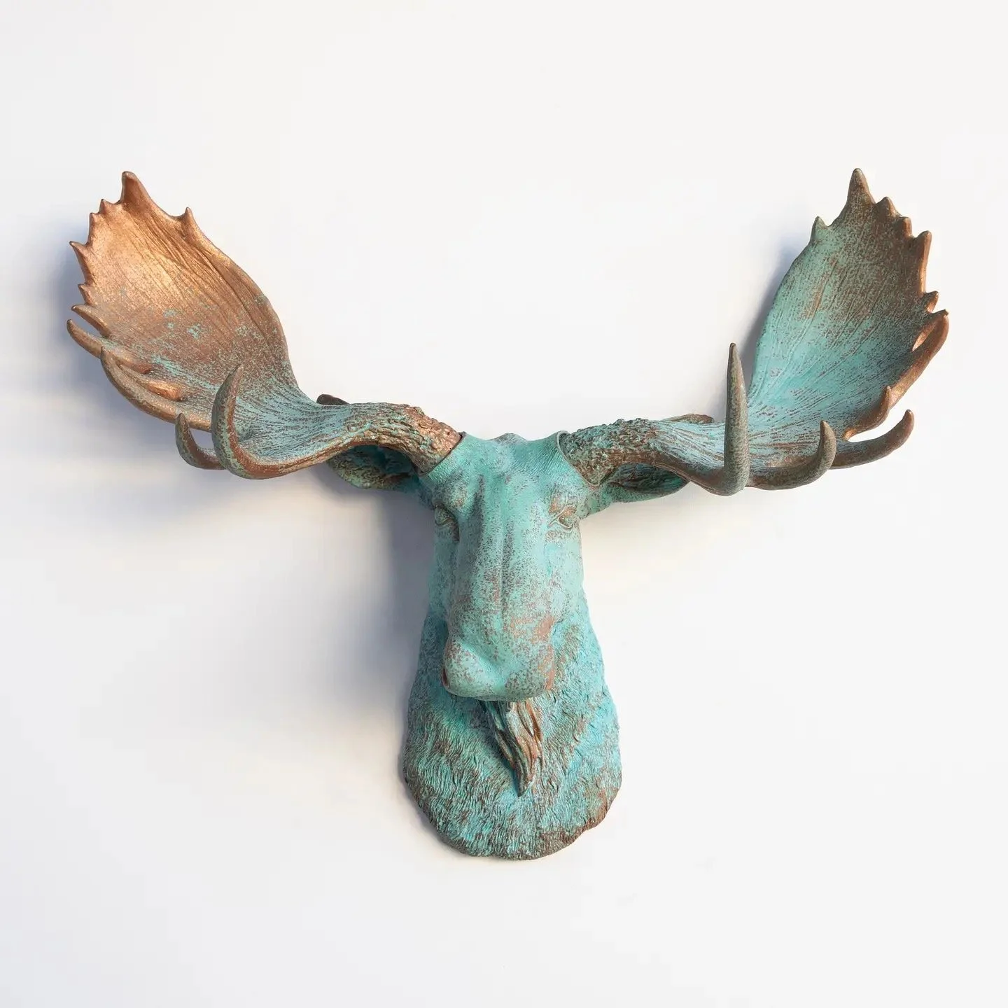 Decorative sculpture of a moose head with large antlers, painted in a distressed turquoise color.