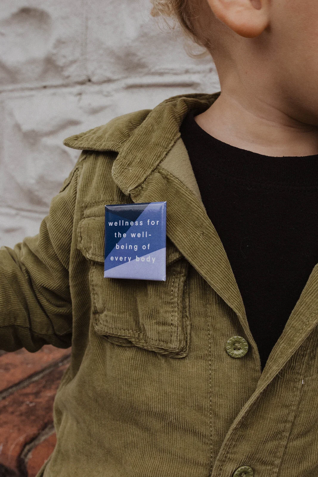 Wellness For The Well-Being of Every Body button on child by Maven Made