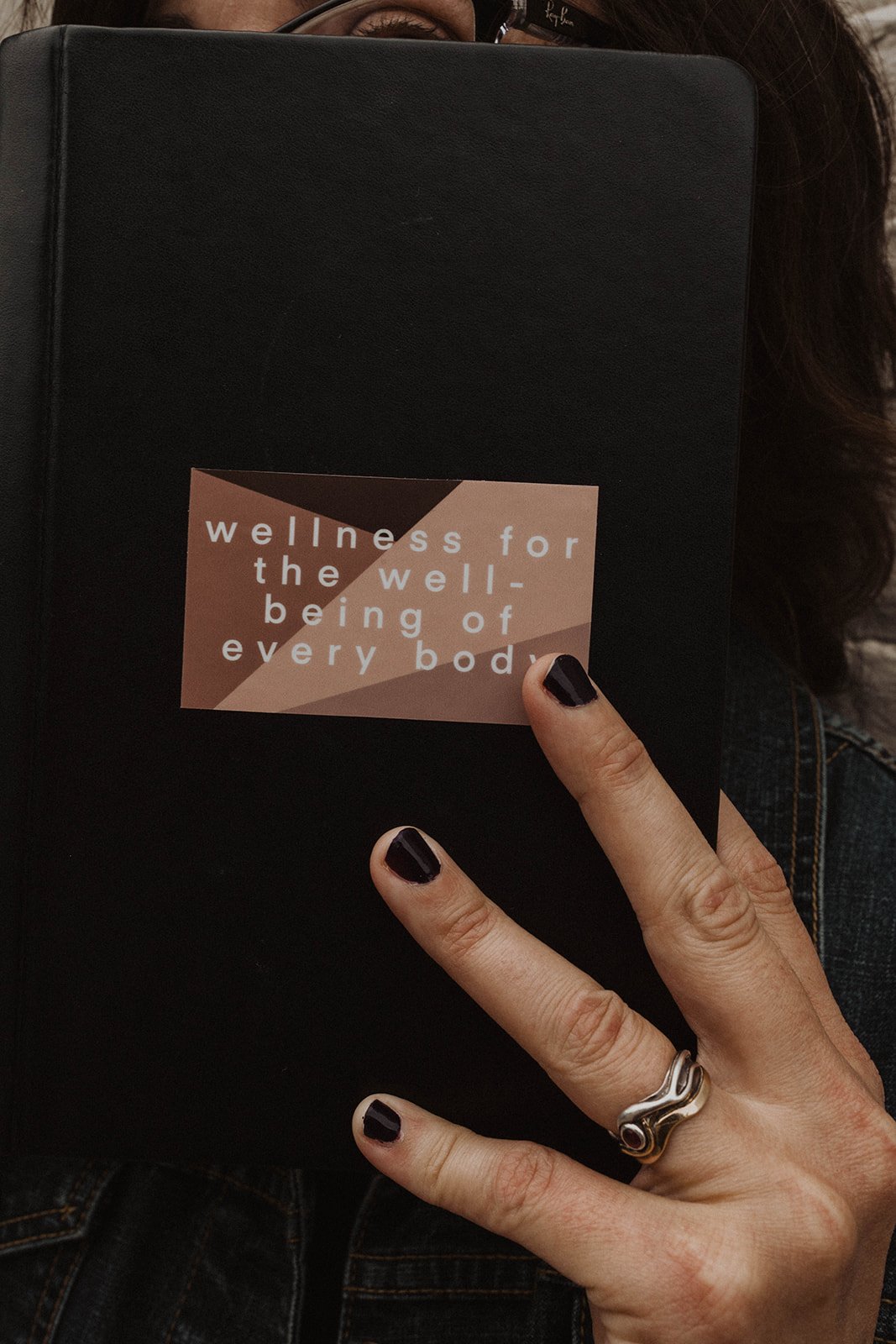 hand opening journal with a sticker on the front