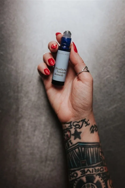 Maven Made Headache and Tension Remedy 10ml cobalt glass roll-on bottle in tattooed hand