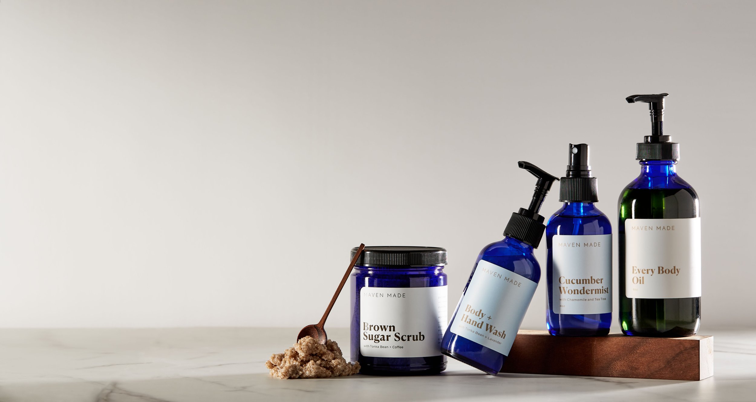 Maven Made skincare product in bblue bottle on table with neutral background.jpg