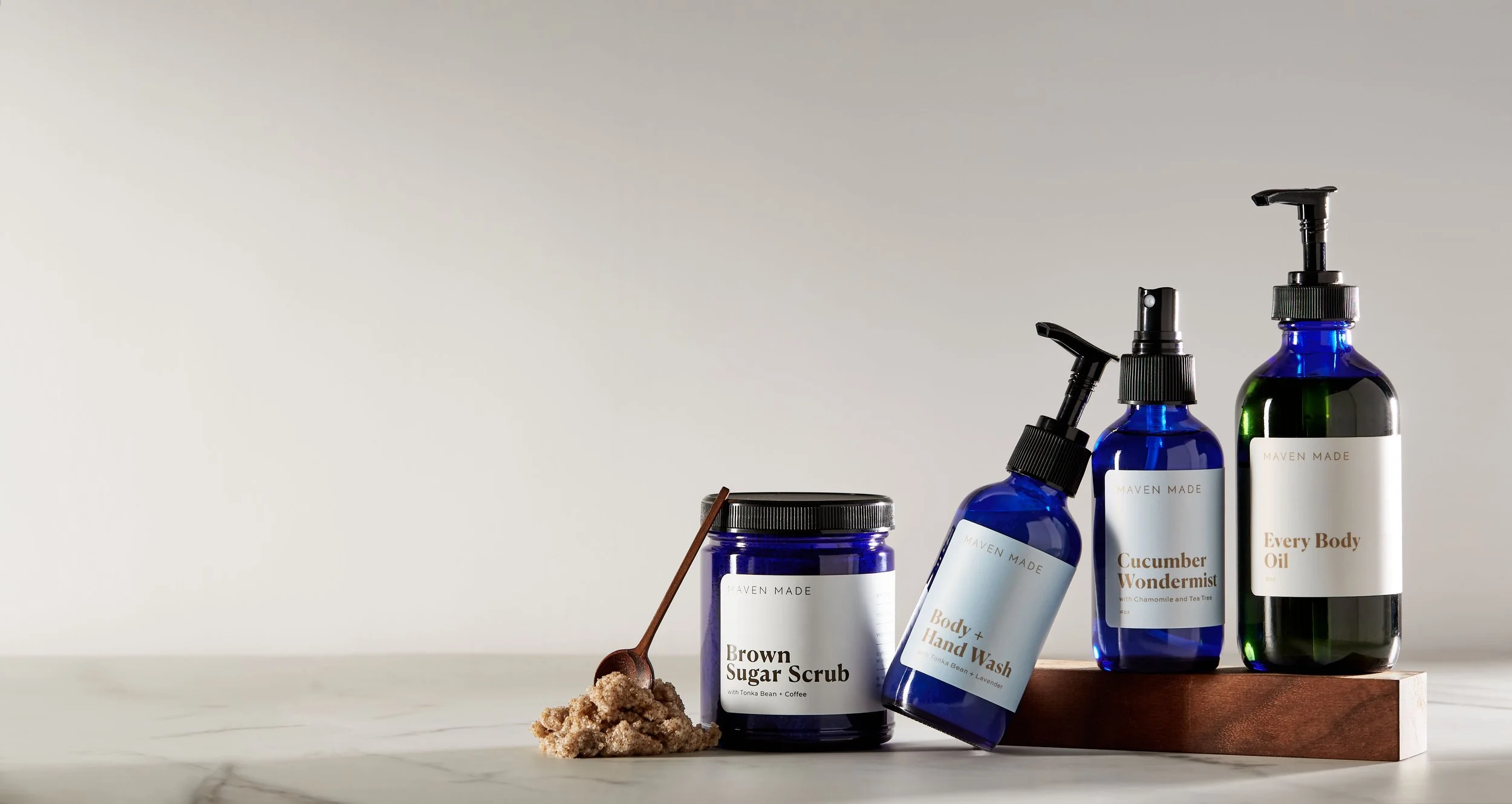 Maven Made skincare product in bblue bottle on table with neutral background.jpg