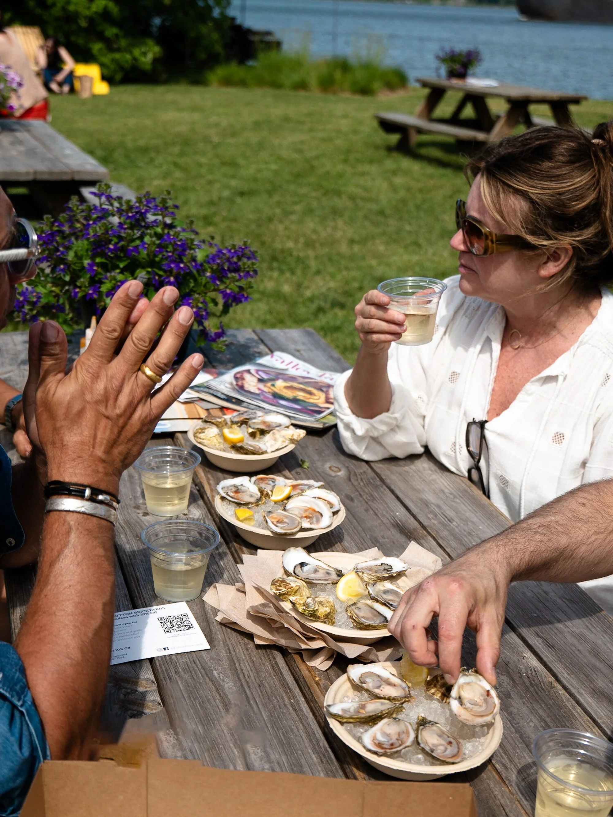 Picnic table full of lobster rolls, oysters on ice, and only good vibes in sight! 🦞🦪✨