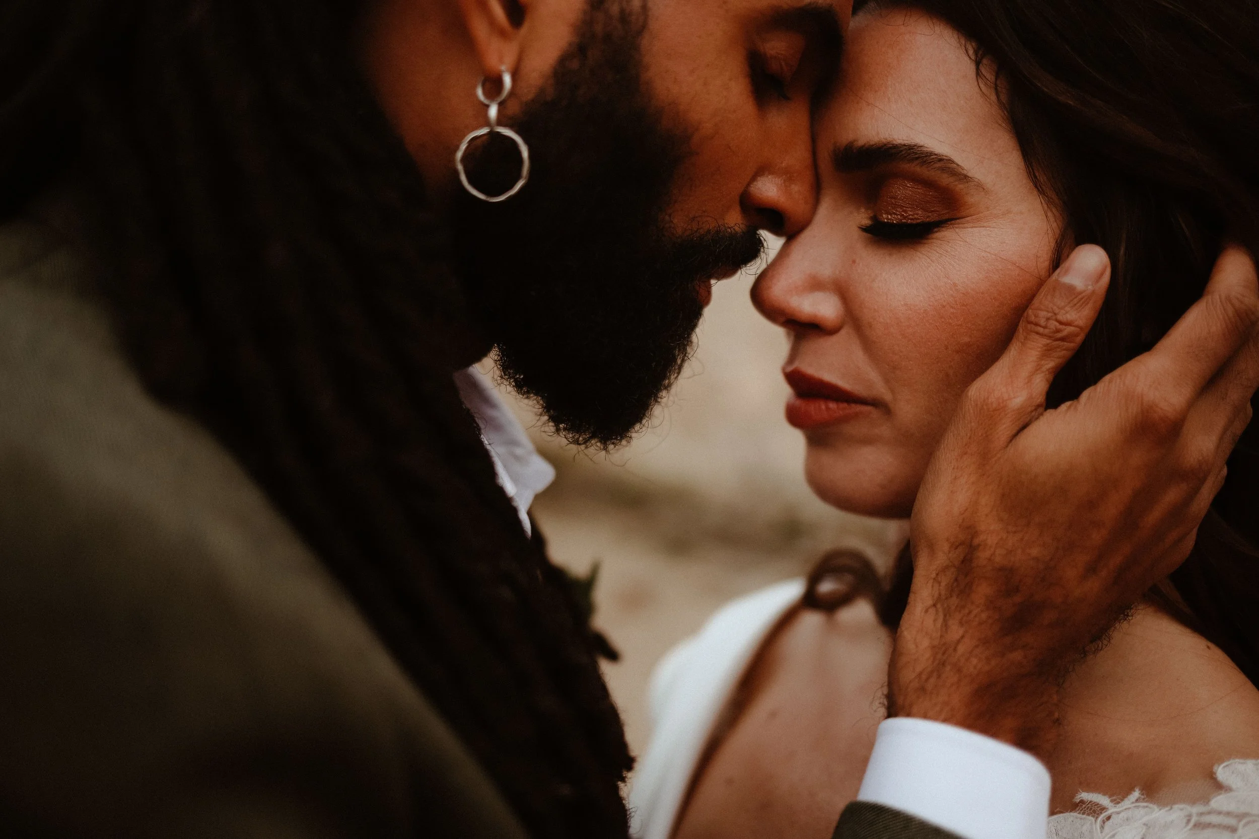 Un homme et une femme se touchent le front, l'homme tient le visage de la femme dans sa main, dans une étreinte intime et touchante.