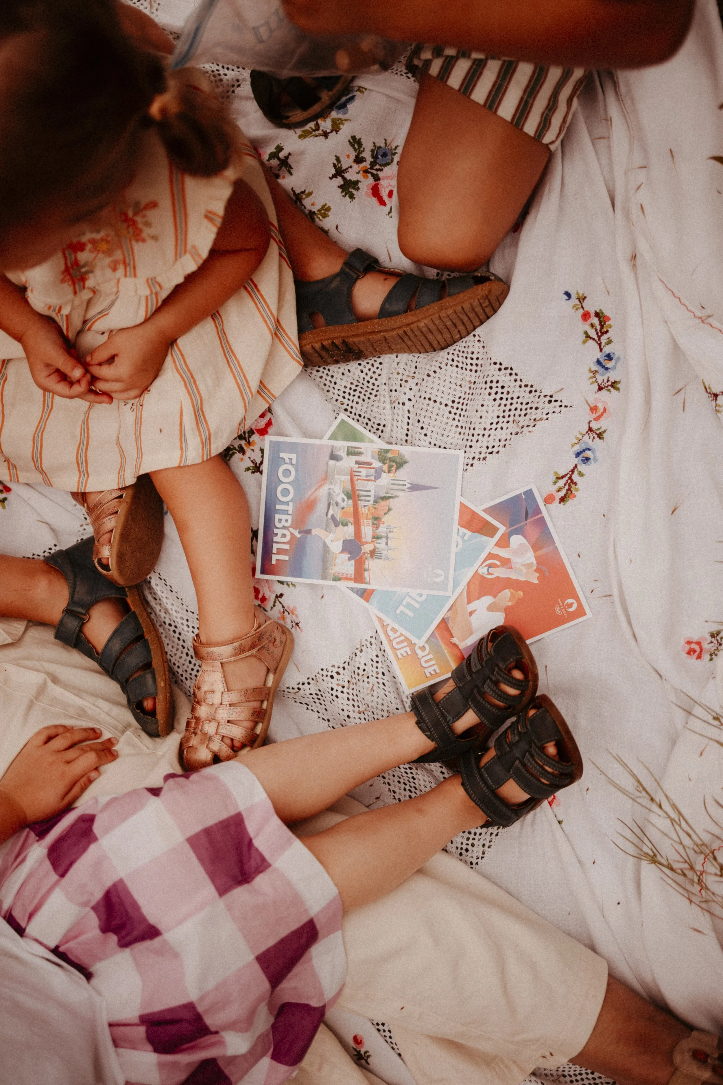 Enfants assis sur une couverture avec des cartes de football