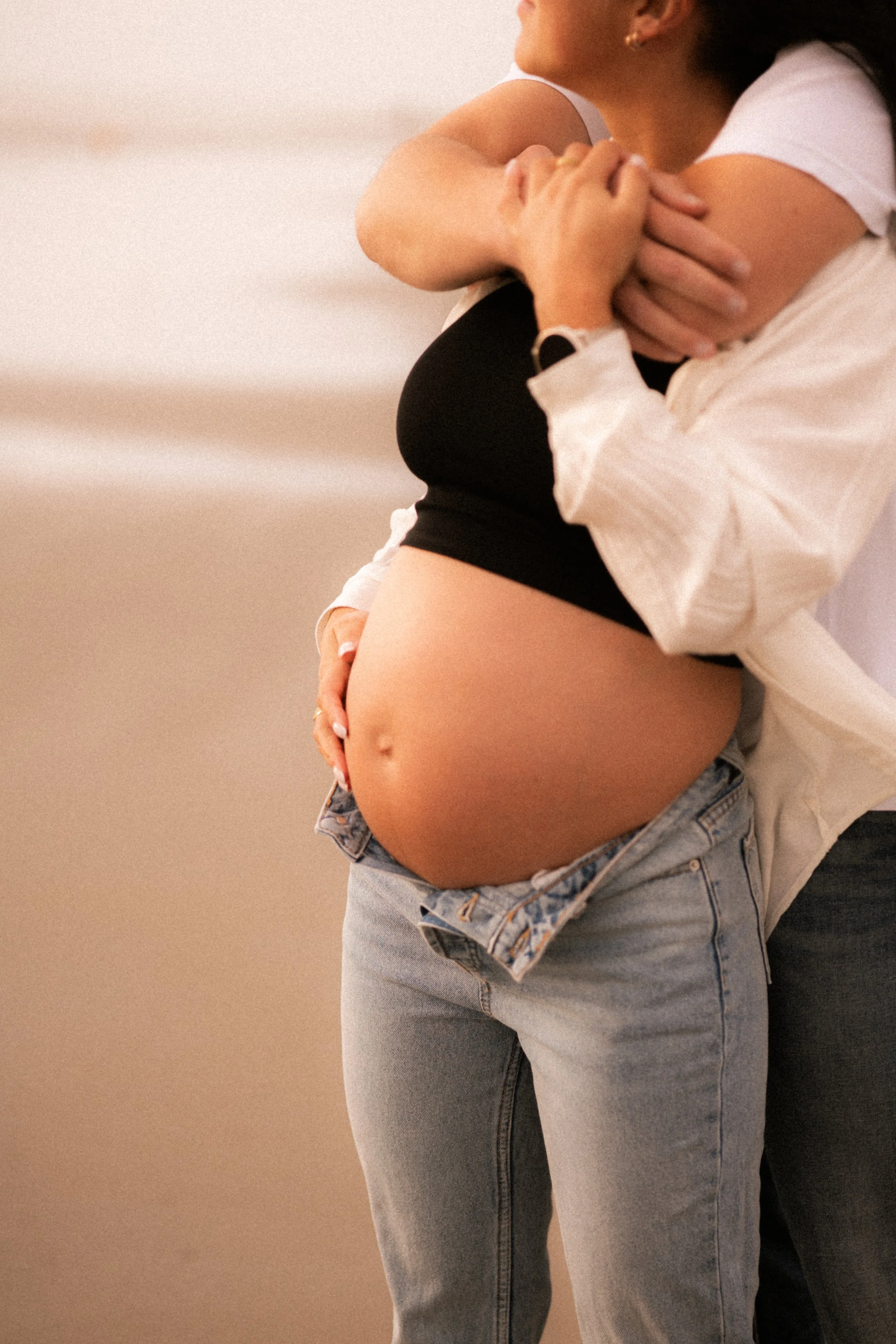 Femme enceinte embrassant quelqu'un. zoom sur son ventre avec jeans décontractés.