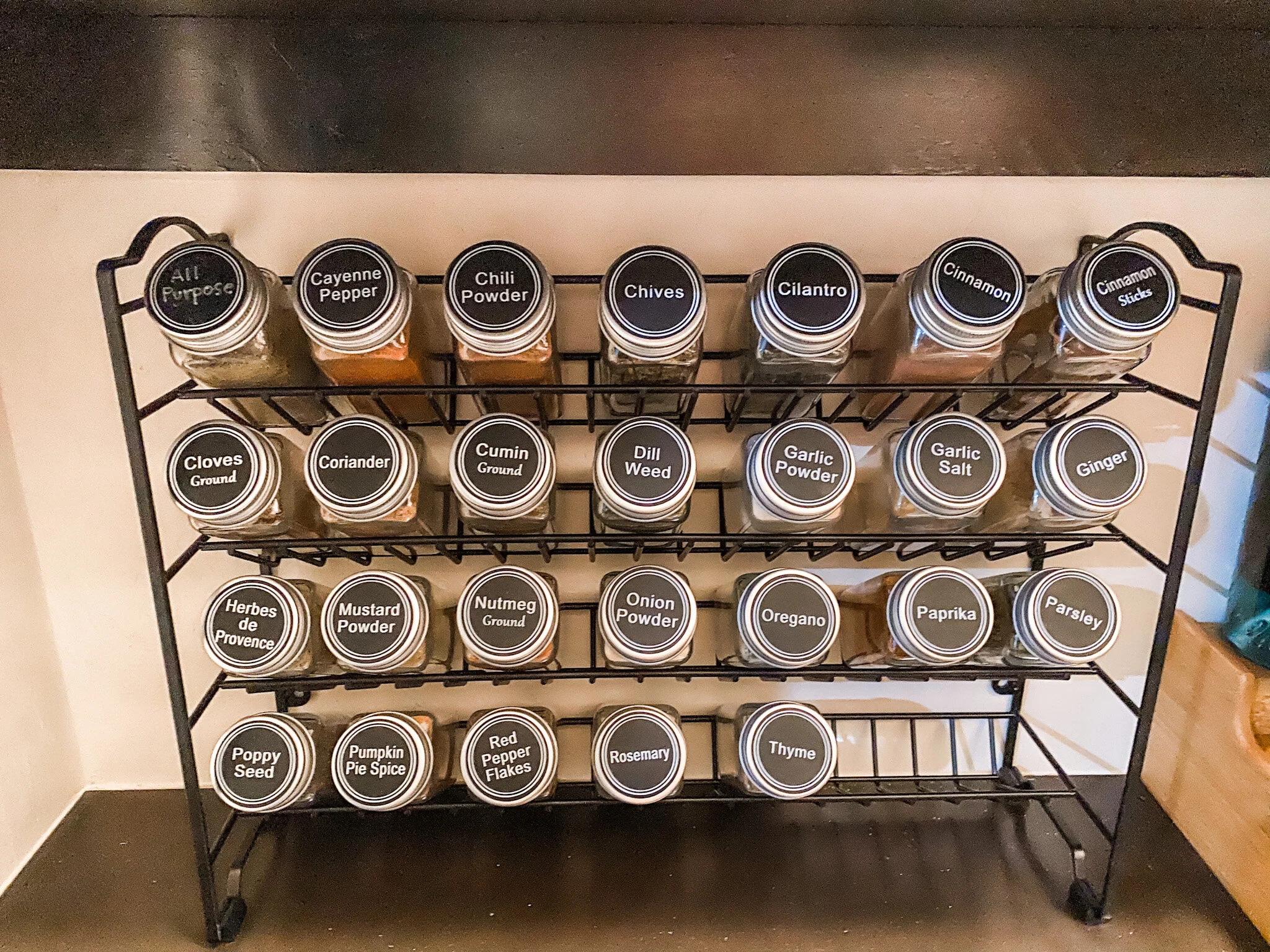 I ordered this spice rack, filled each jar with the existing spices, and labeled them to turn the spice area into a sleek, organized, and pretty element.