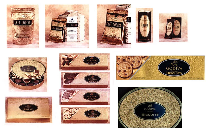 Assorted Godiva chocolates and biscuits packaging, including boxes, tins, and assorted flavored chocolates.
