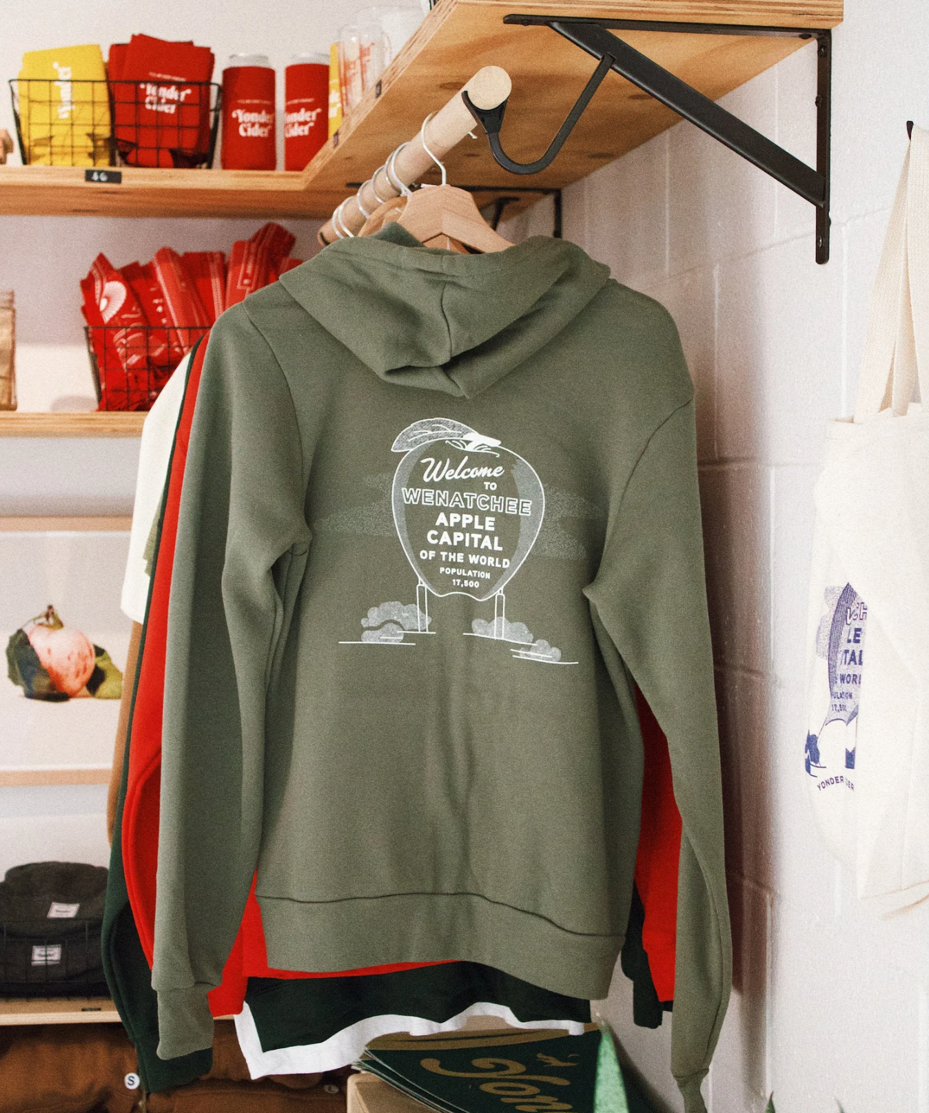 Green zip-up hoodie with wenatchee apple country sign on the back.