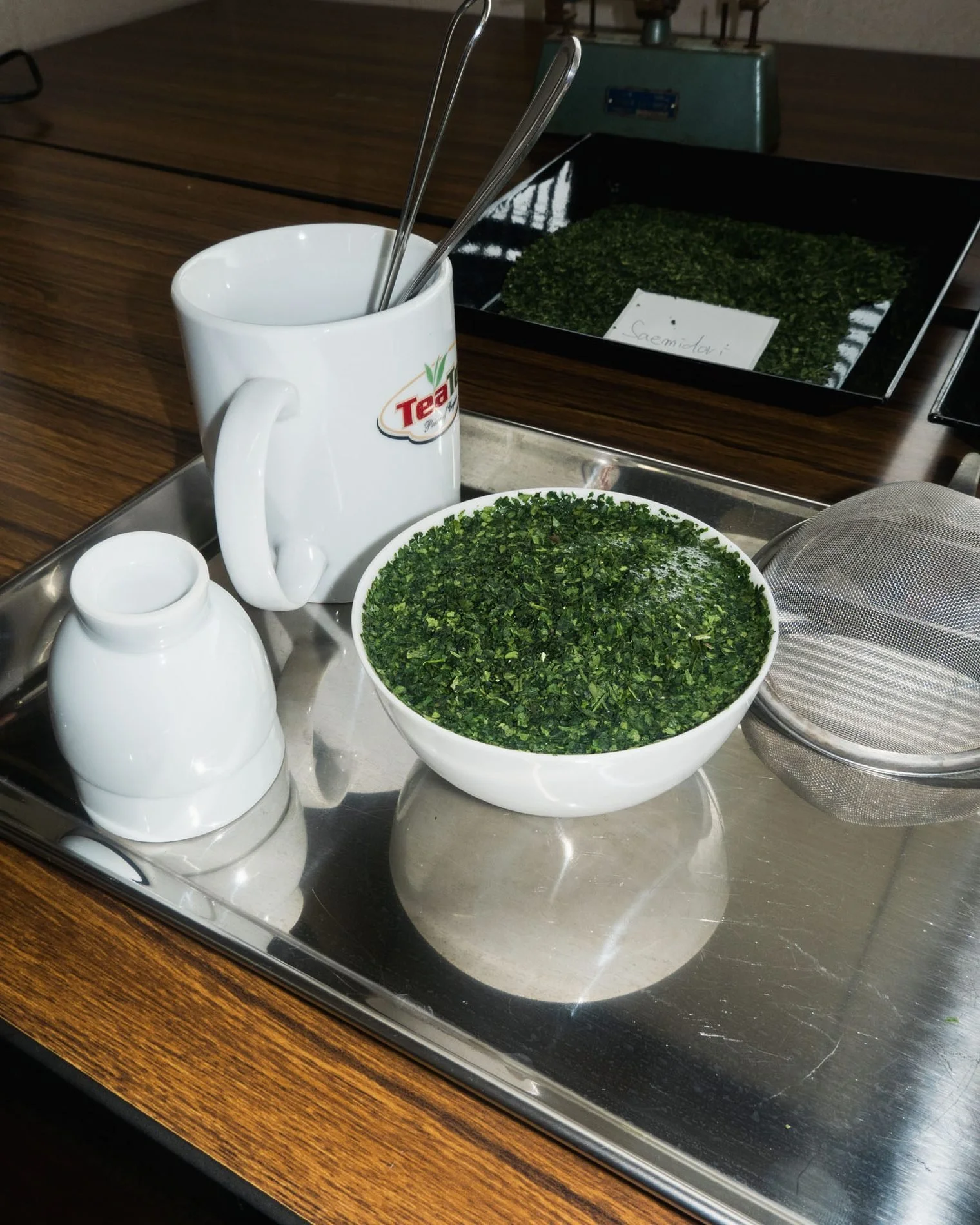 Fresh tea leaves in a white tasting bowl at a tea appraisal in Shizuoka