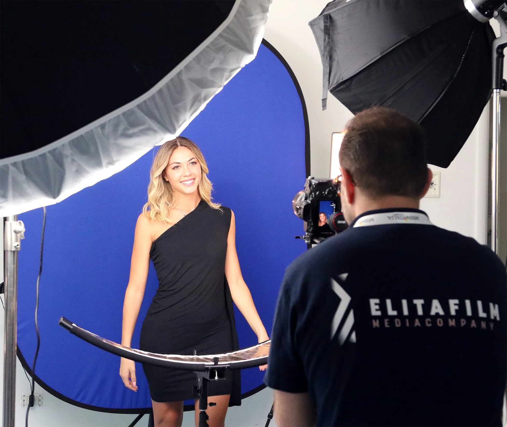 Donna che posa davanti a uno schermo blu durante una sessione videografica con illuminazione professionale