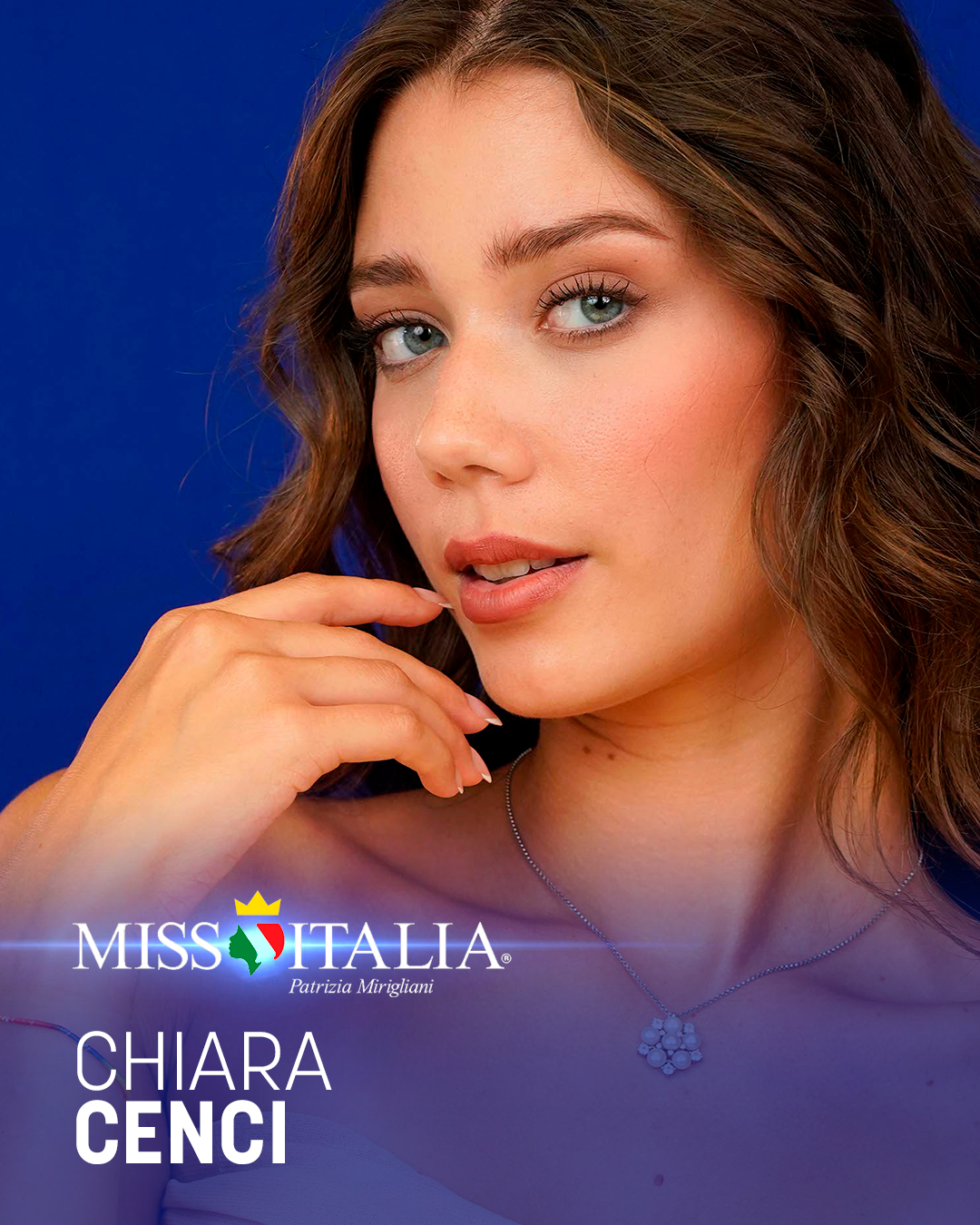 Prima piano di una donna con capelli castani ondulati, che indossa un anello con fiore e una collana, sfondo blu, con logo Miss Italia e testo con il nome Chiara Cenci.