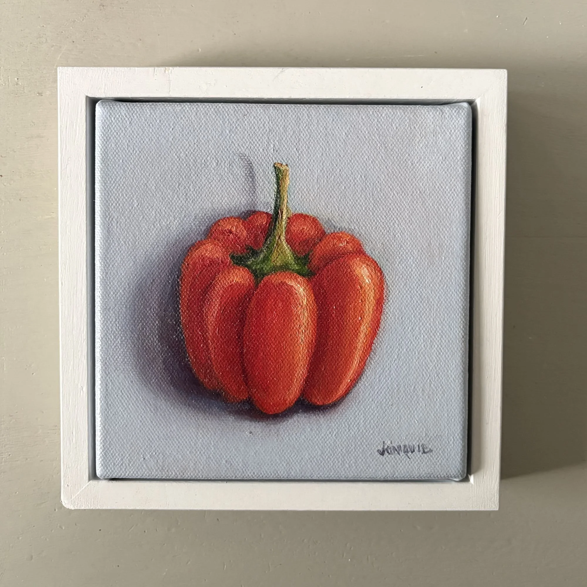 Mini oil painting of a red bell pepper on a soft grey background.