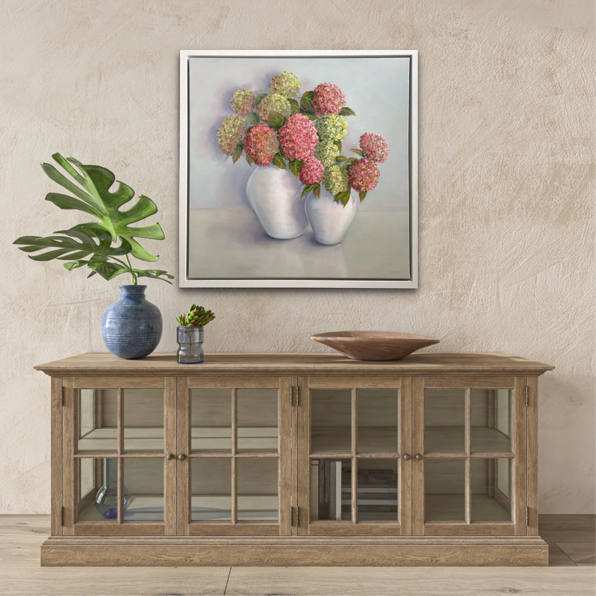 Framed pink and green hydrangea oil painting displayed in a hallway over a sideboard console table.JPG