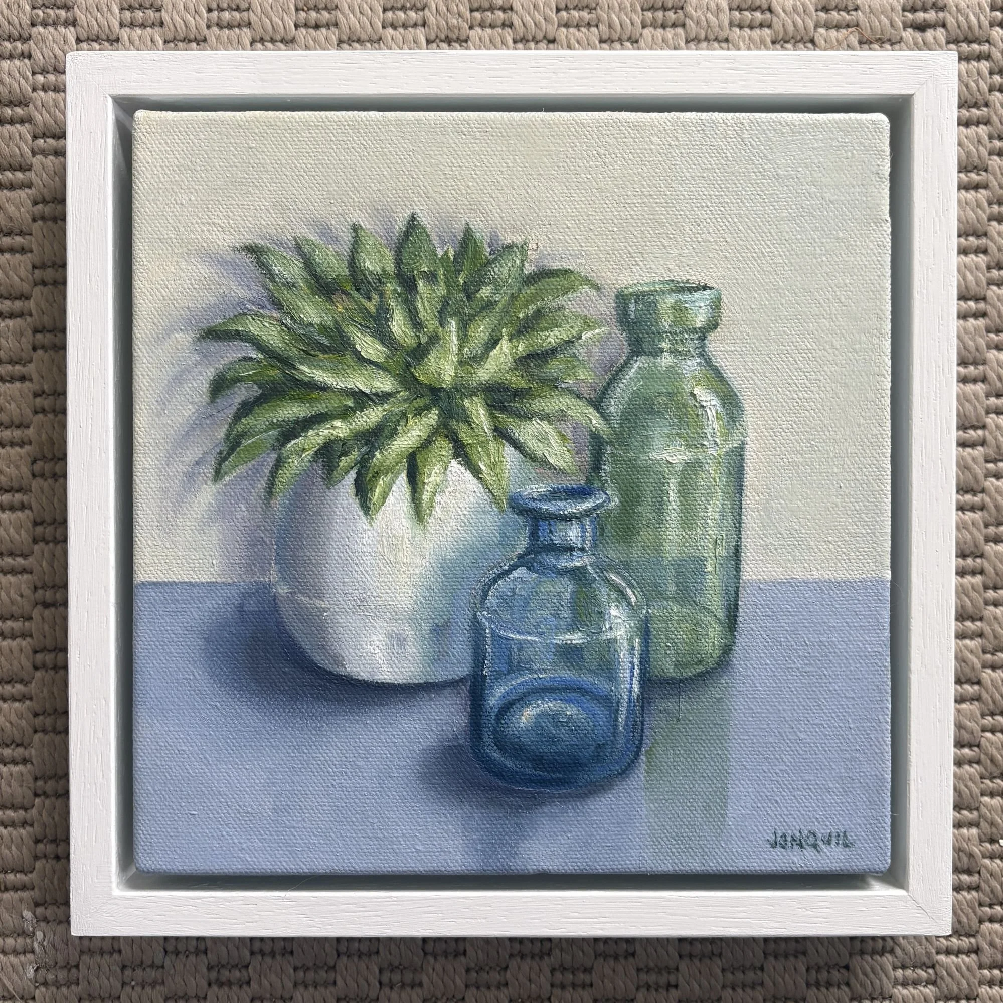 Small framed oil painting of a succulent with vintage glass bottles by Jonquil Williamson.JPG