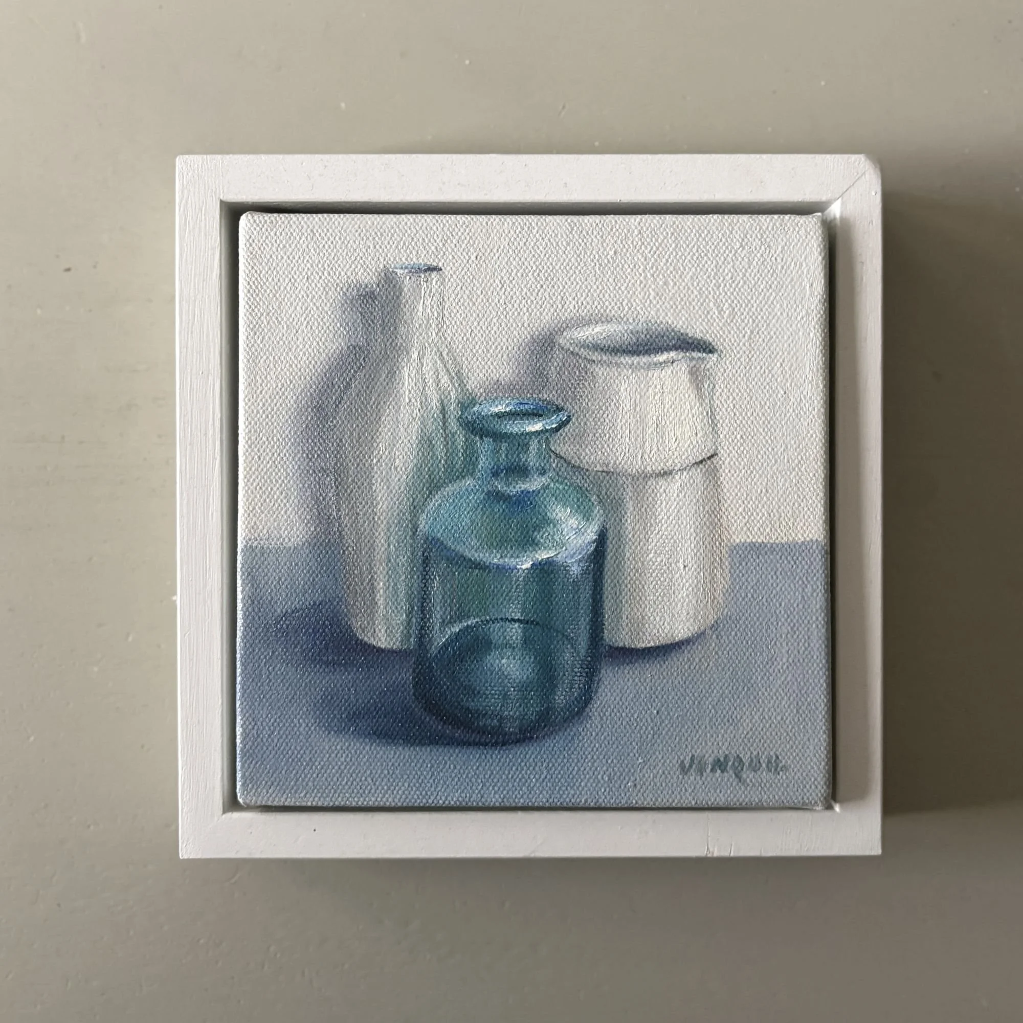 Small oil painting of blue glass bottle with white ceramic jug and vase on a grey surface.