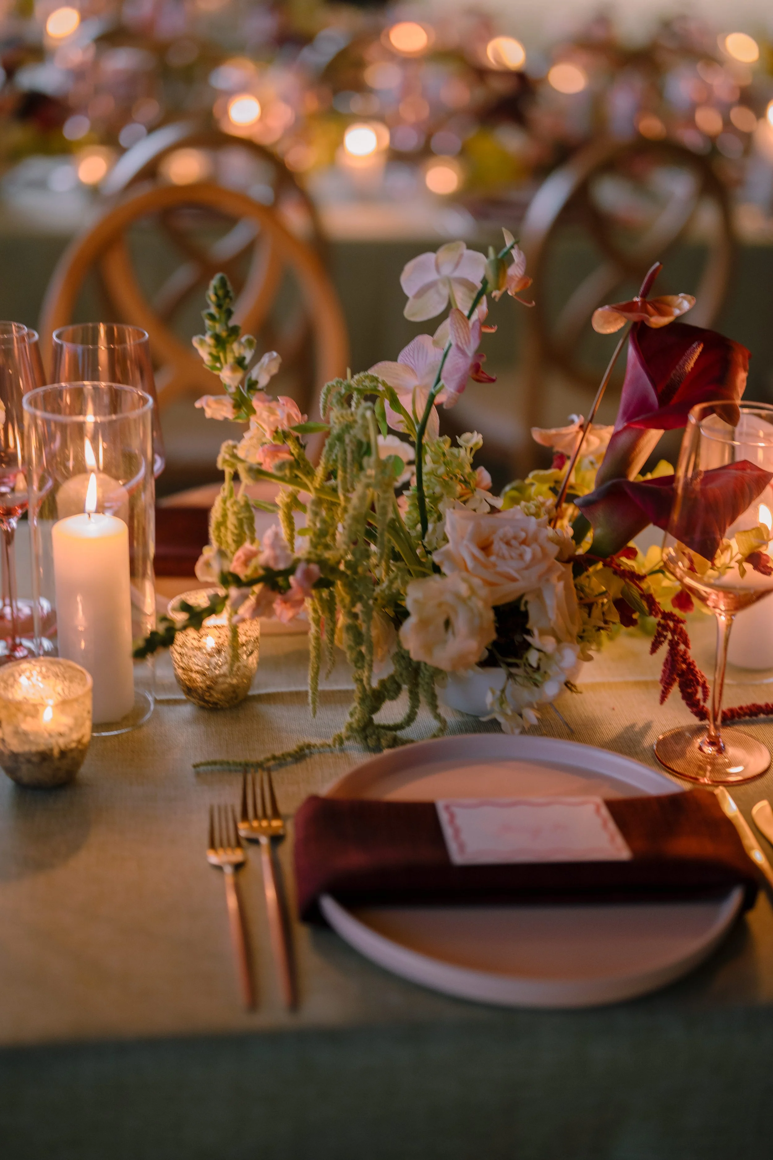 Modern wedding table setting with artistic floral arrangements in warm tones.