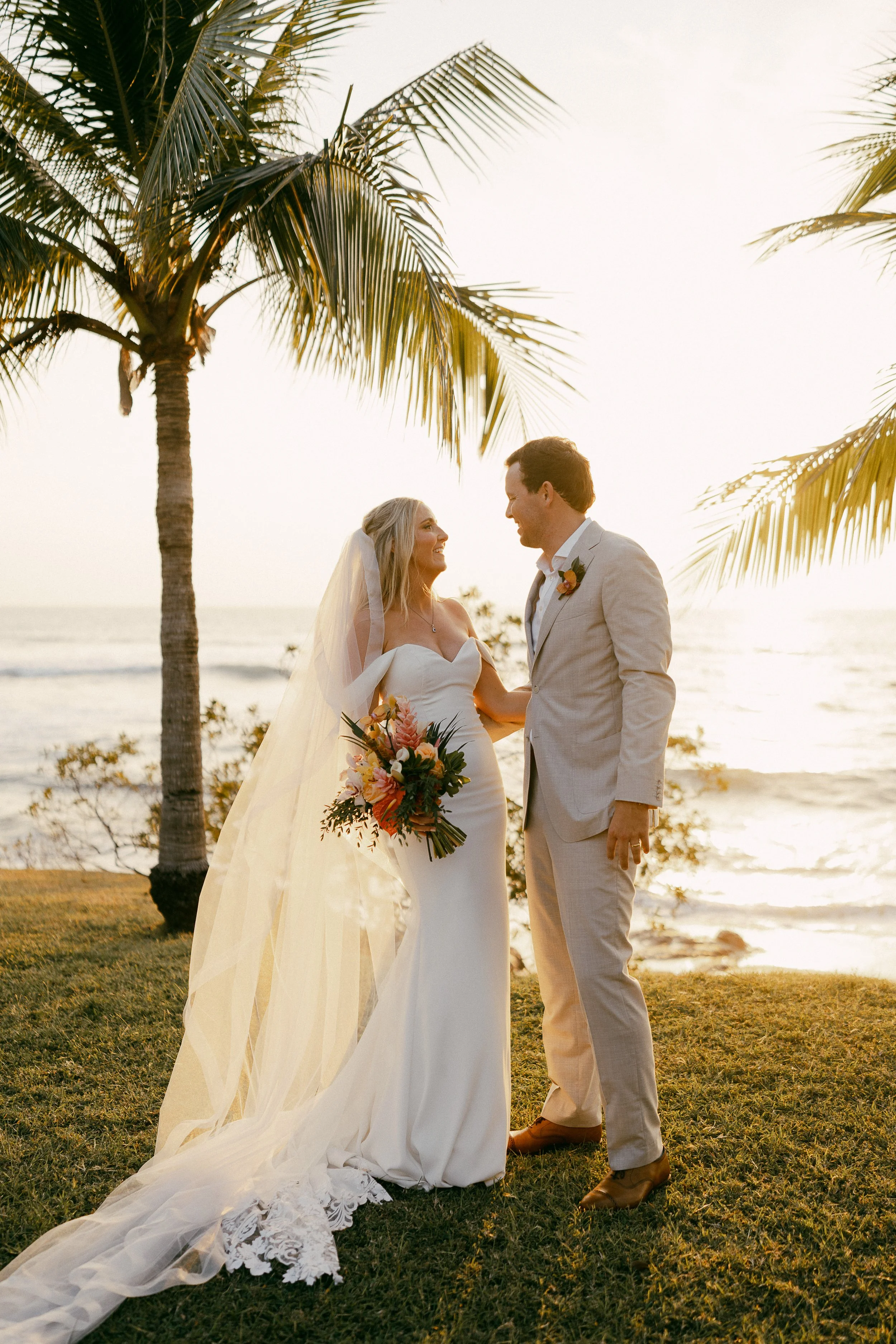 Newlywed couple surrounded by pastel tropical flowers at Hacienda Pinilla in Guanacaste, Costa Rica.