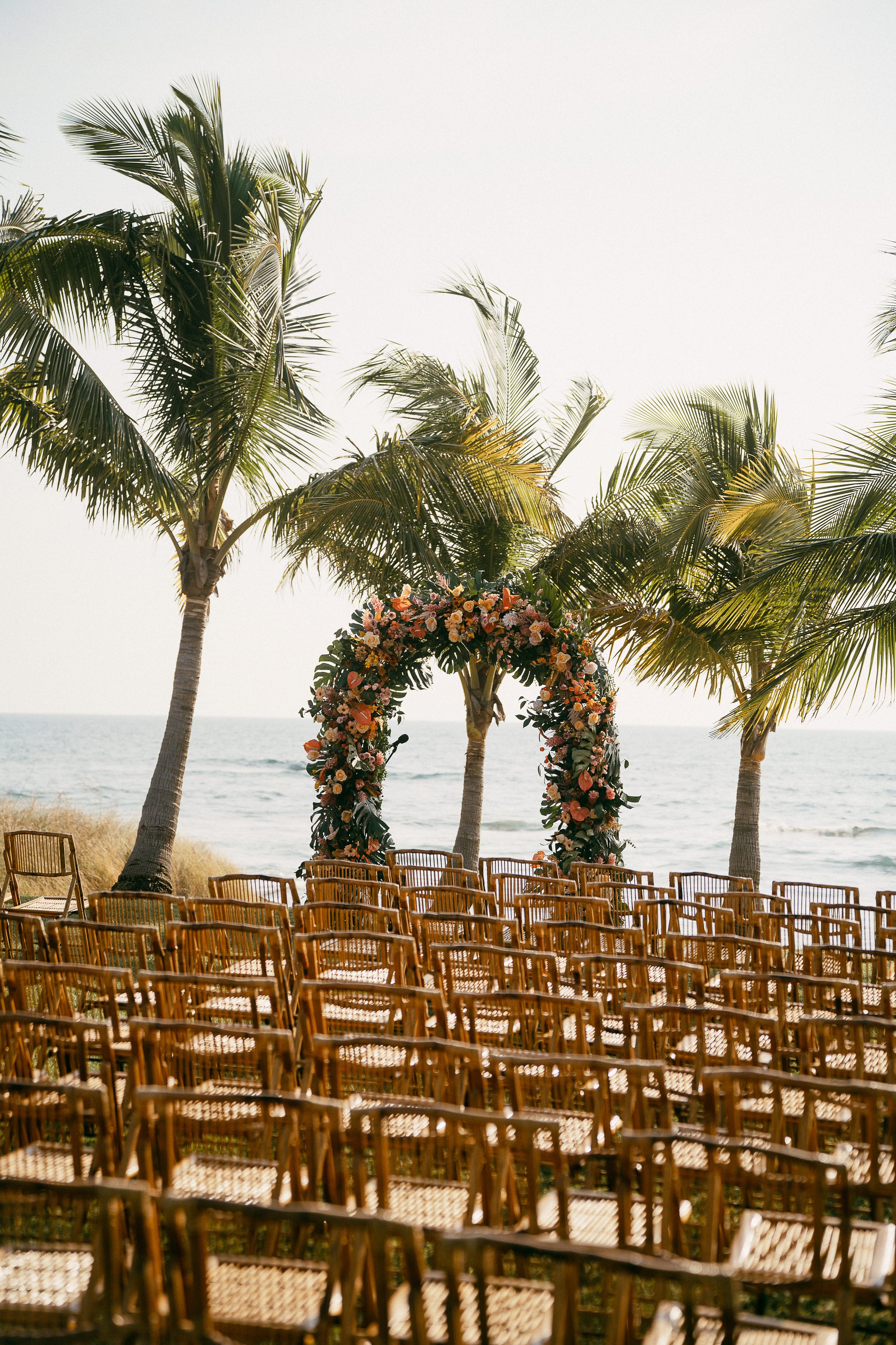 Wedding ceremony décor with pastel tropical blooms and lush greenery in Costa Rica.
