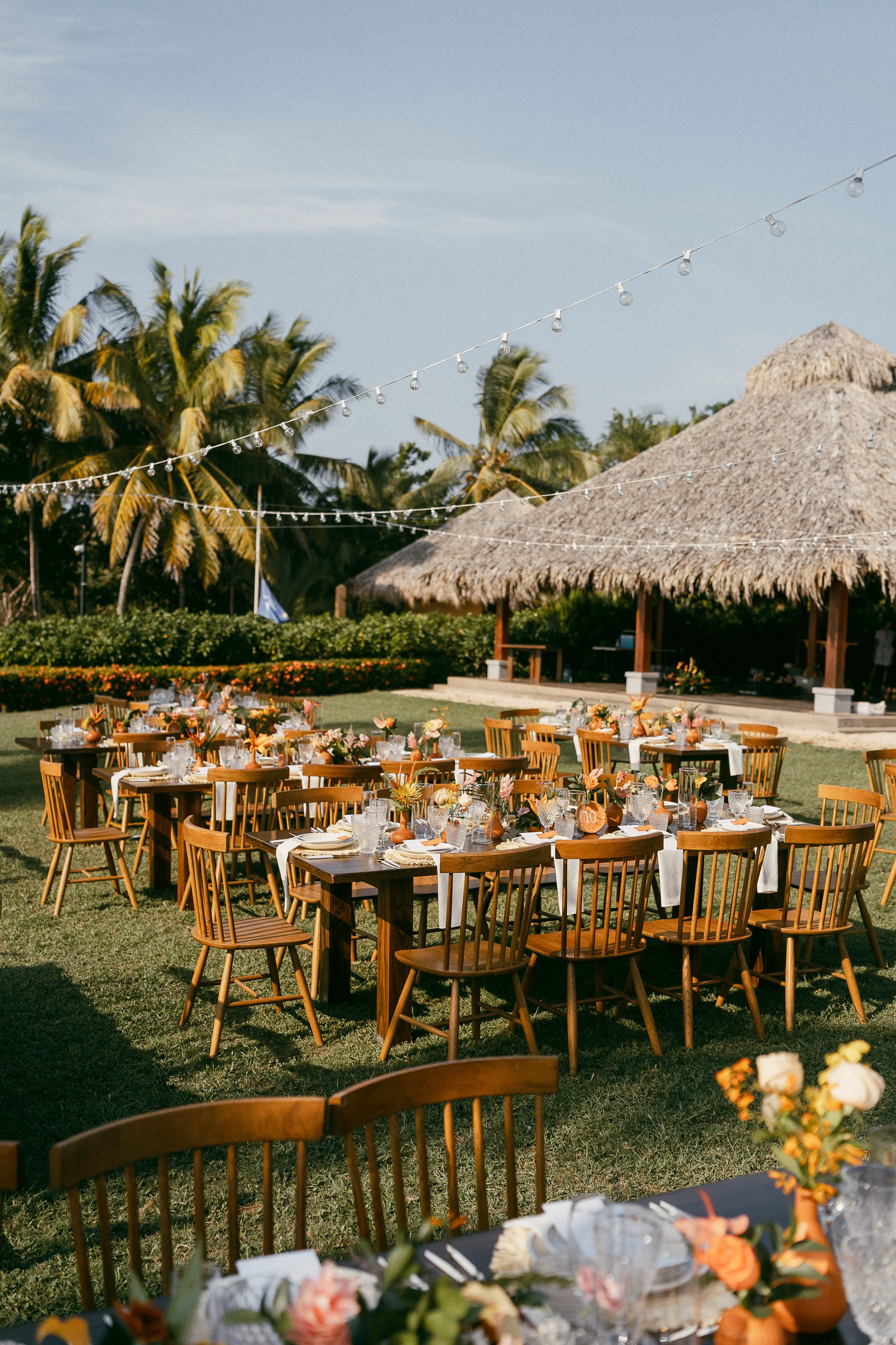 Wedding centerpiece with tropical flowers in blush, peach, orange and terracotta tones at Hacienda Pinilla.
