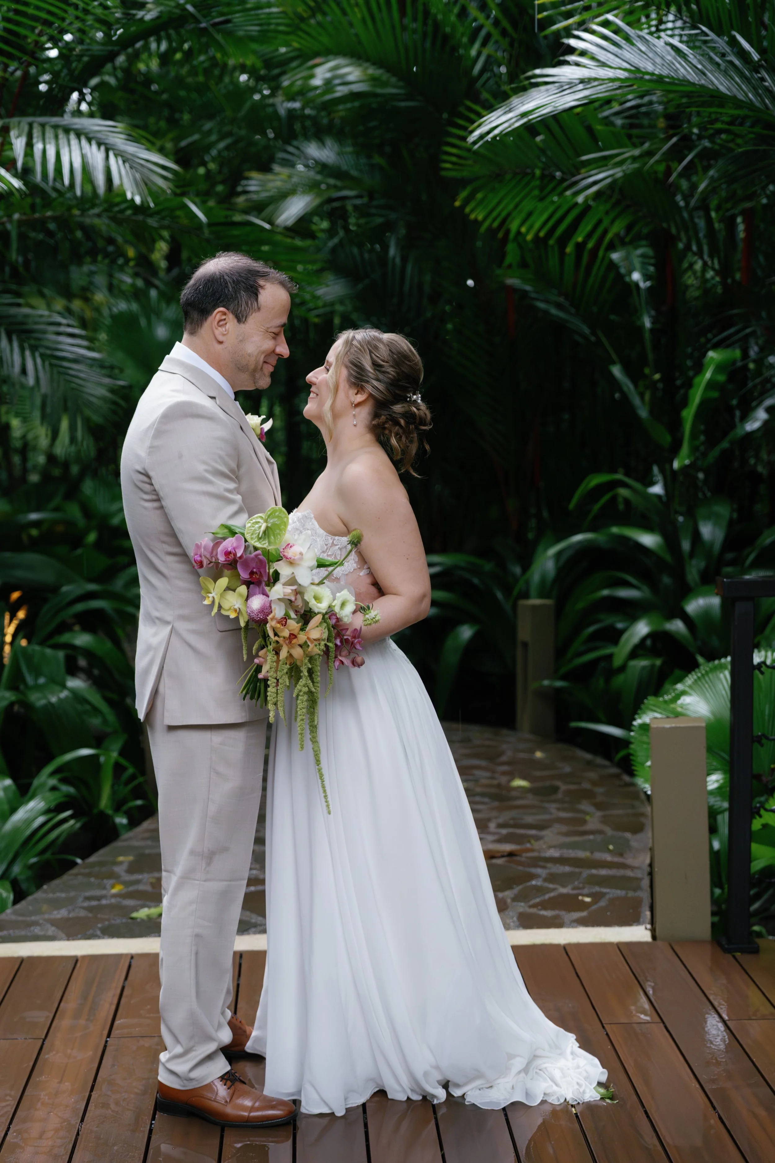 Newlywed couple surrounded by lush rainforest scenery in La Fortuna, Costa Rica.