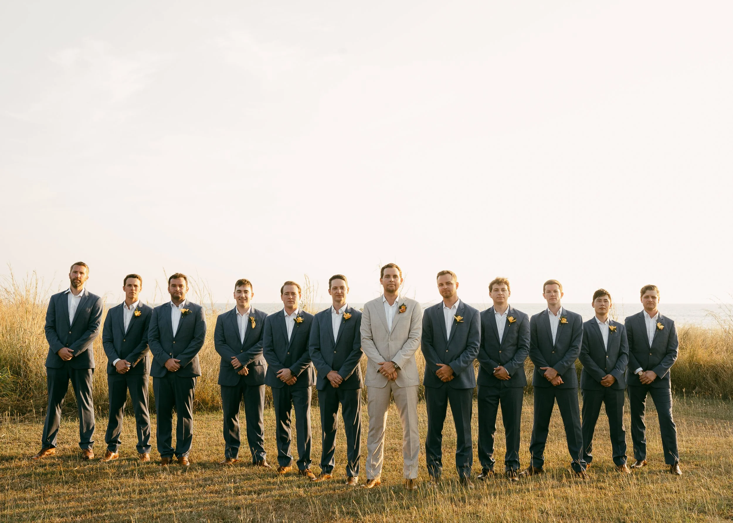 Groomsmen wearing tropical boutonnieres in blush, orange and terracotta tones at Hacienda Pinilla.