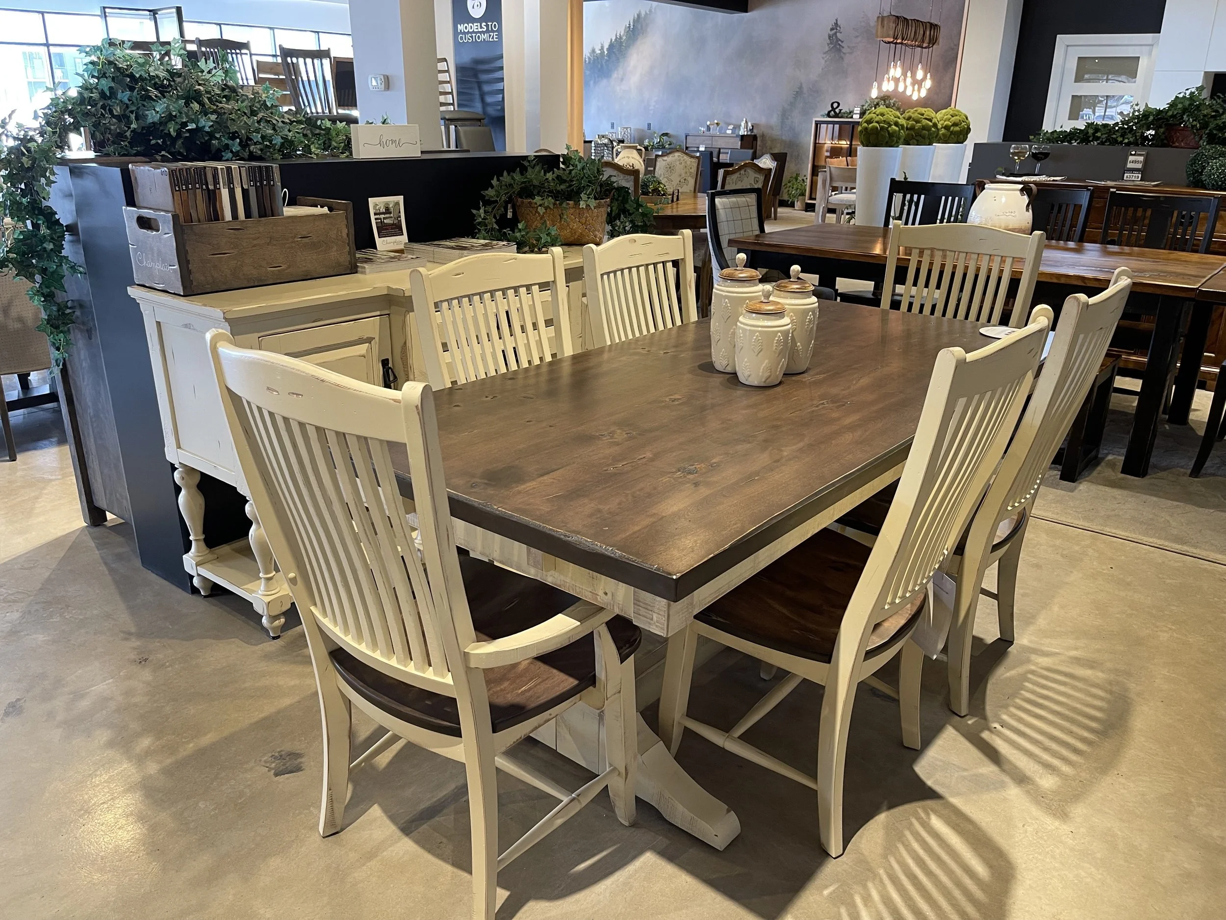 A wooden dining table with six cream-colored chairs in a home furniture store.