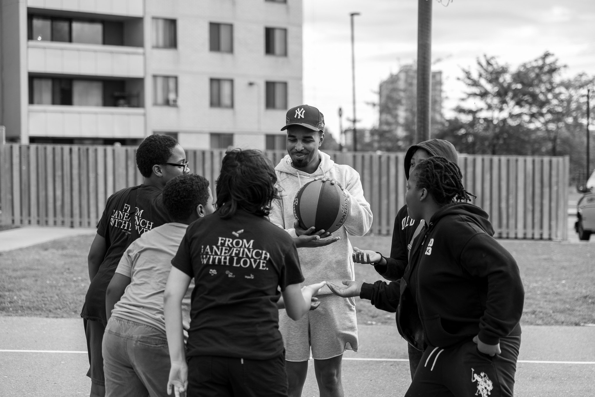 playing basketball on an outdoor court in Jane-Finch