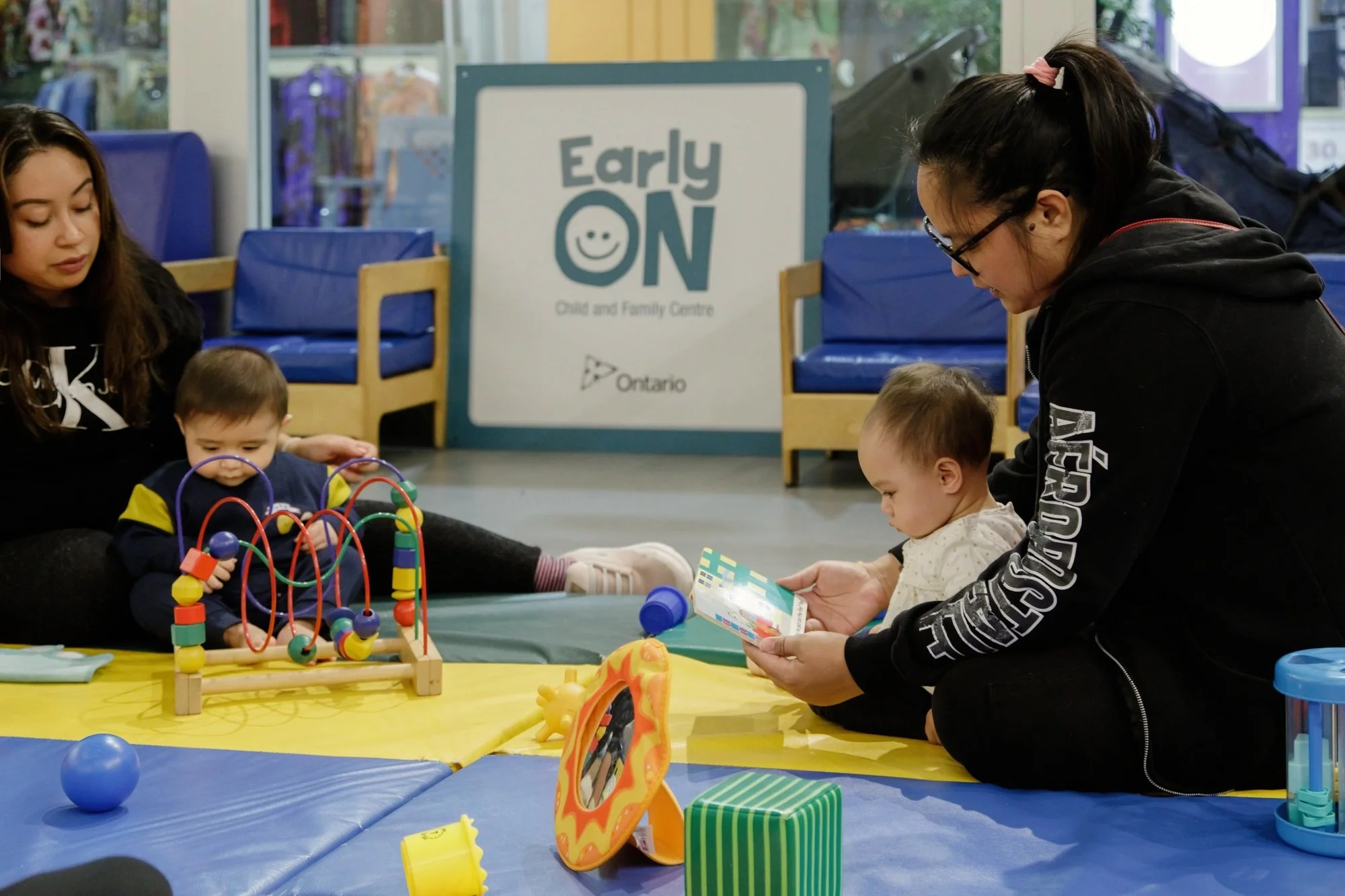 Parent reading a book to a child at the EarlyON Centre