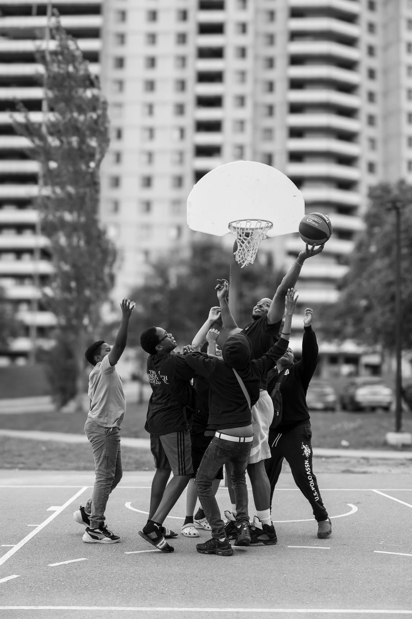 Youth playing basketball outside in Jane-Finch