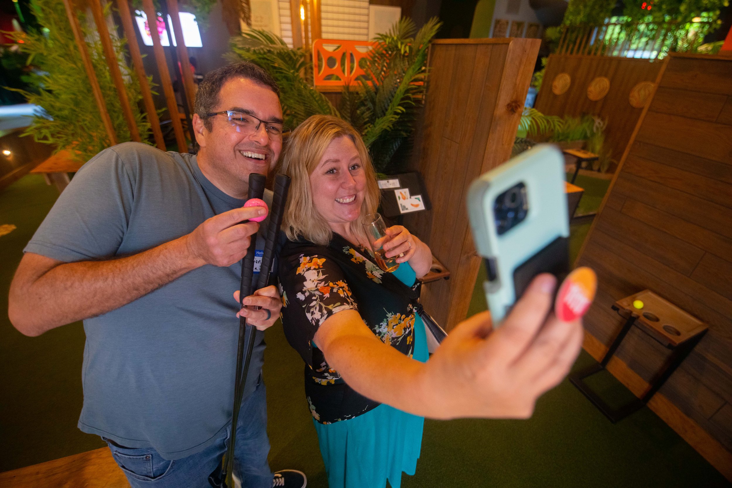  Attendee posing for a selfie while playing mini golf during Mini Golf Gathering for Grievers on 6.4.22 