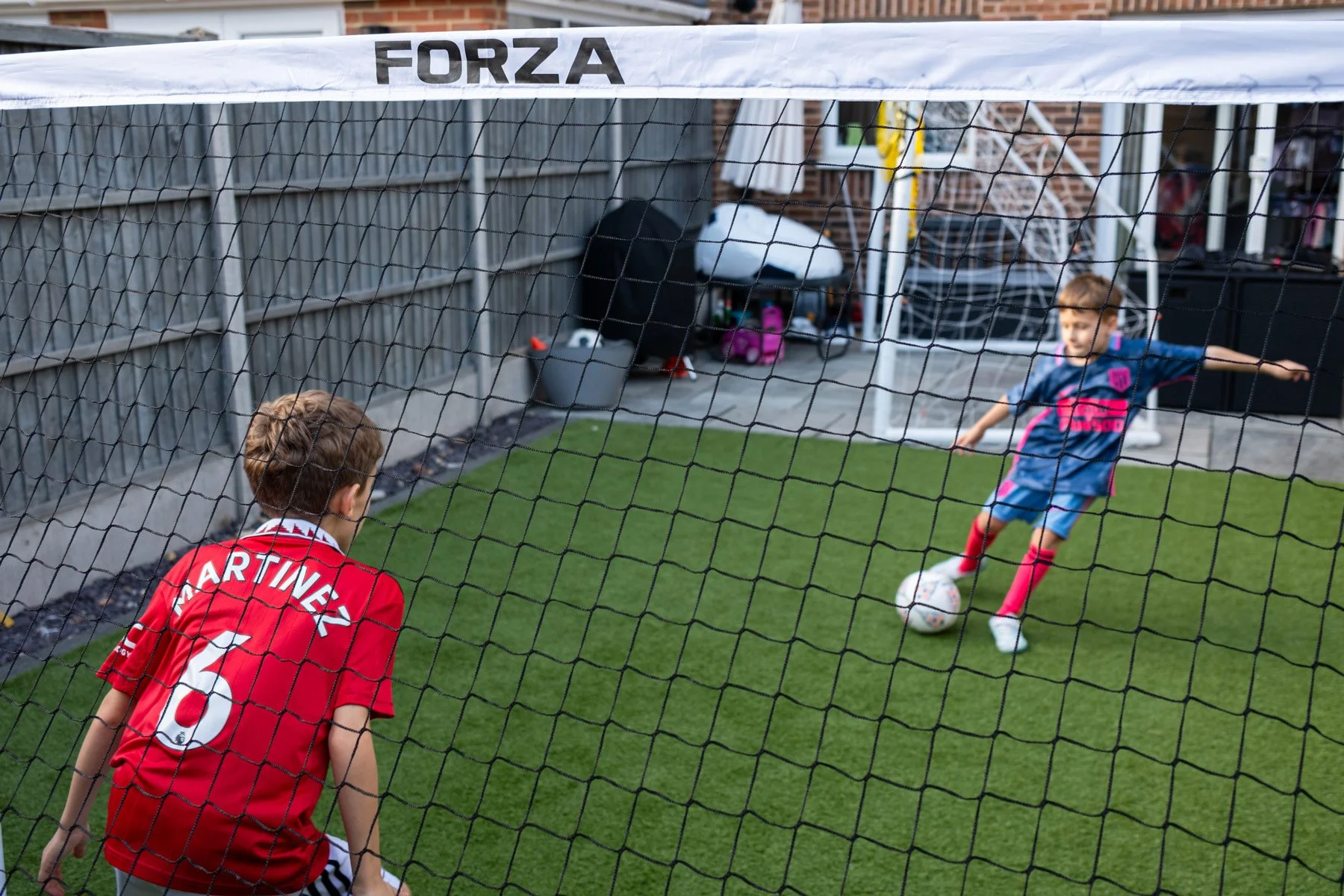 Boys in back garden playing with FORZA goal