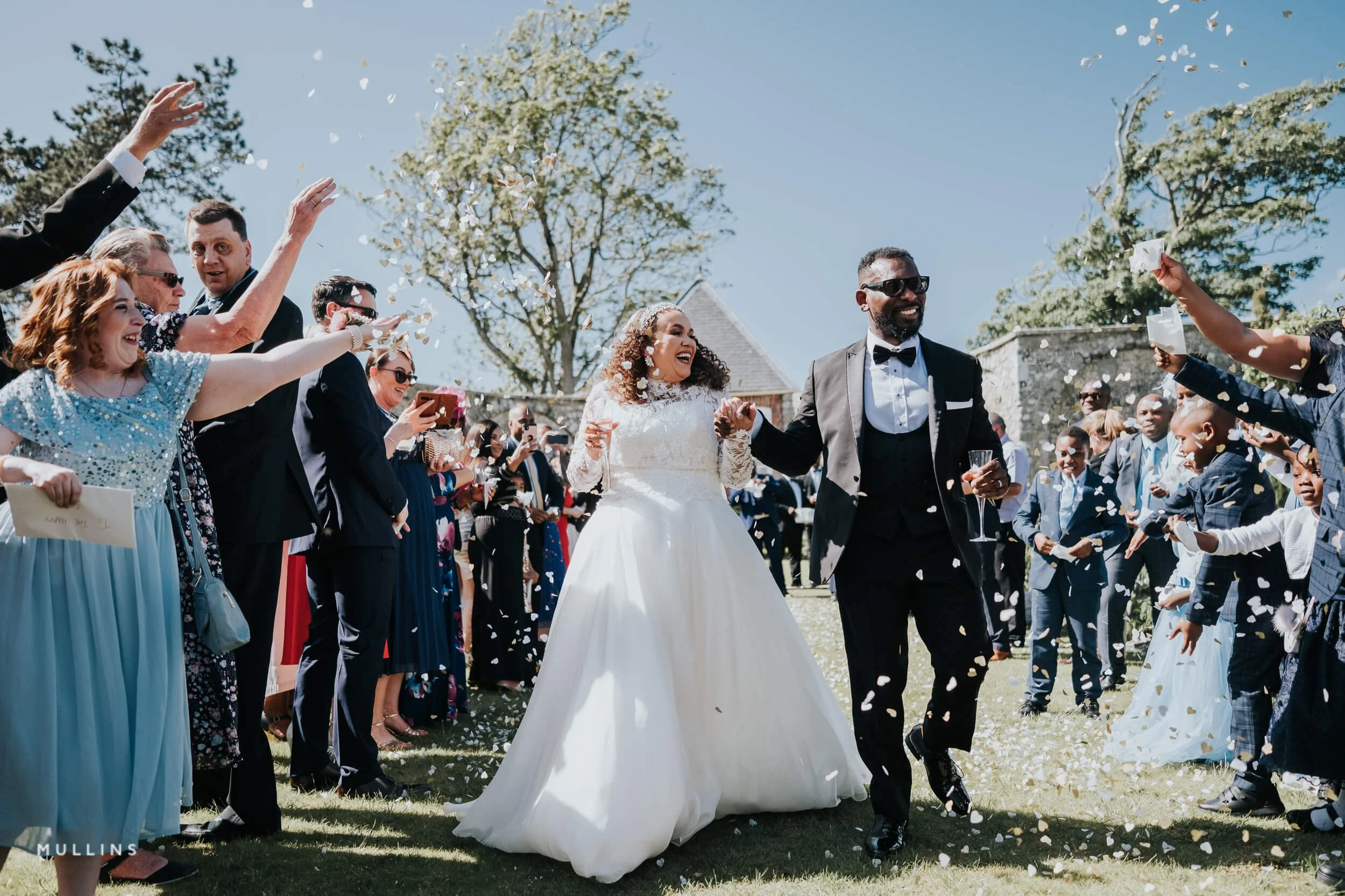 Bride and Groom running through confetti at Gileston Manor