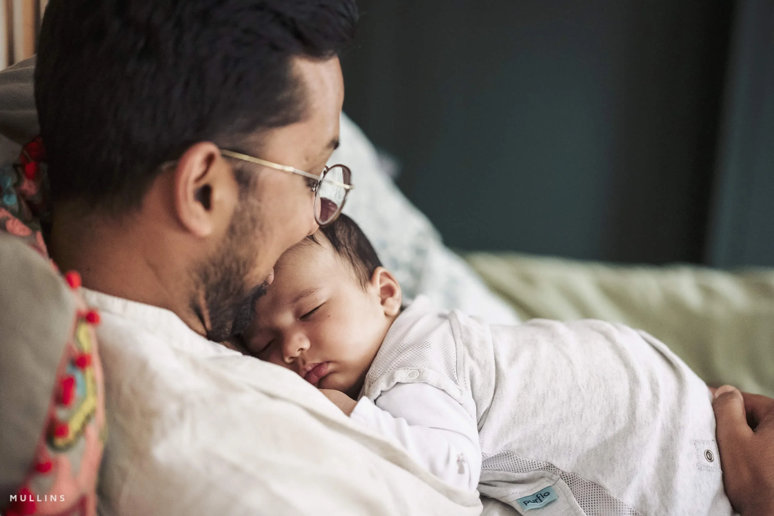 A father cradles his newborn son