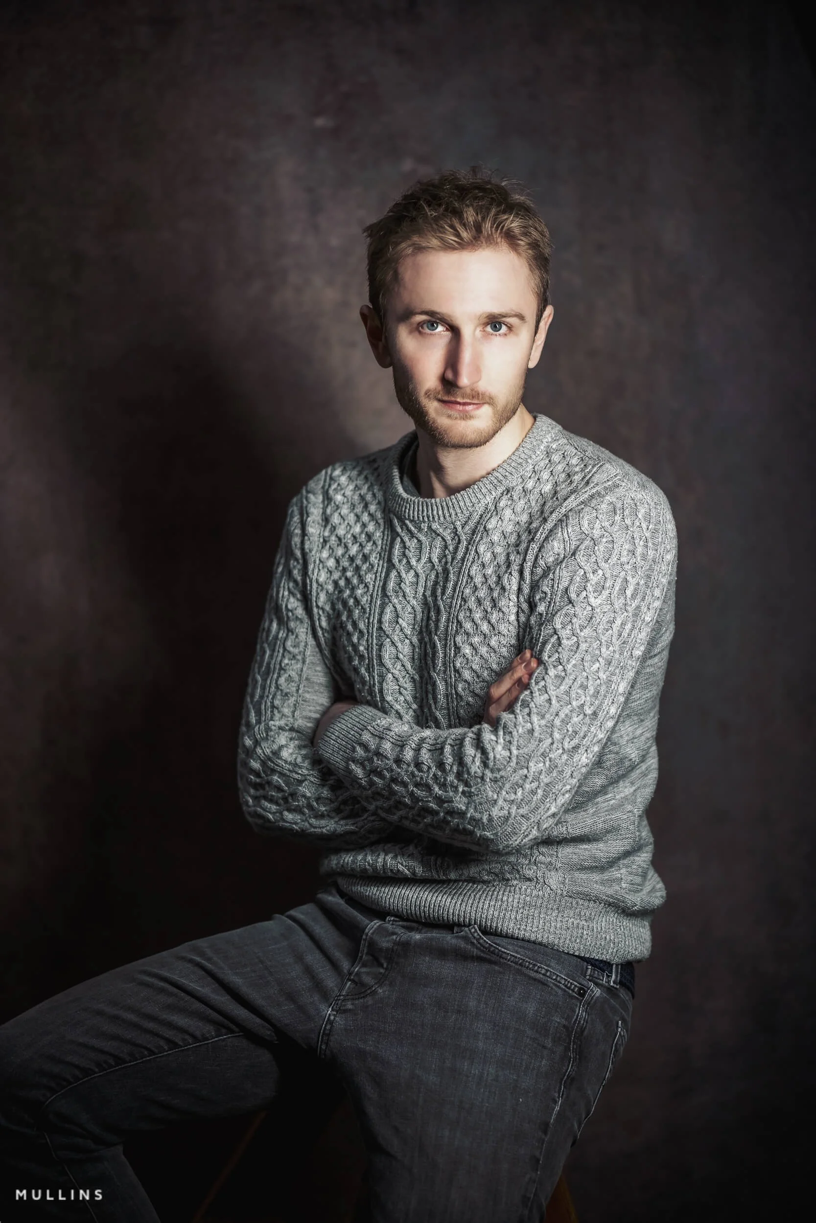 Actor in grey woolen jumper in studio