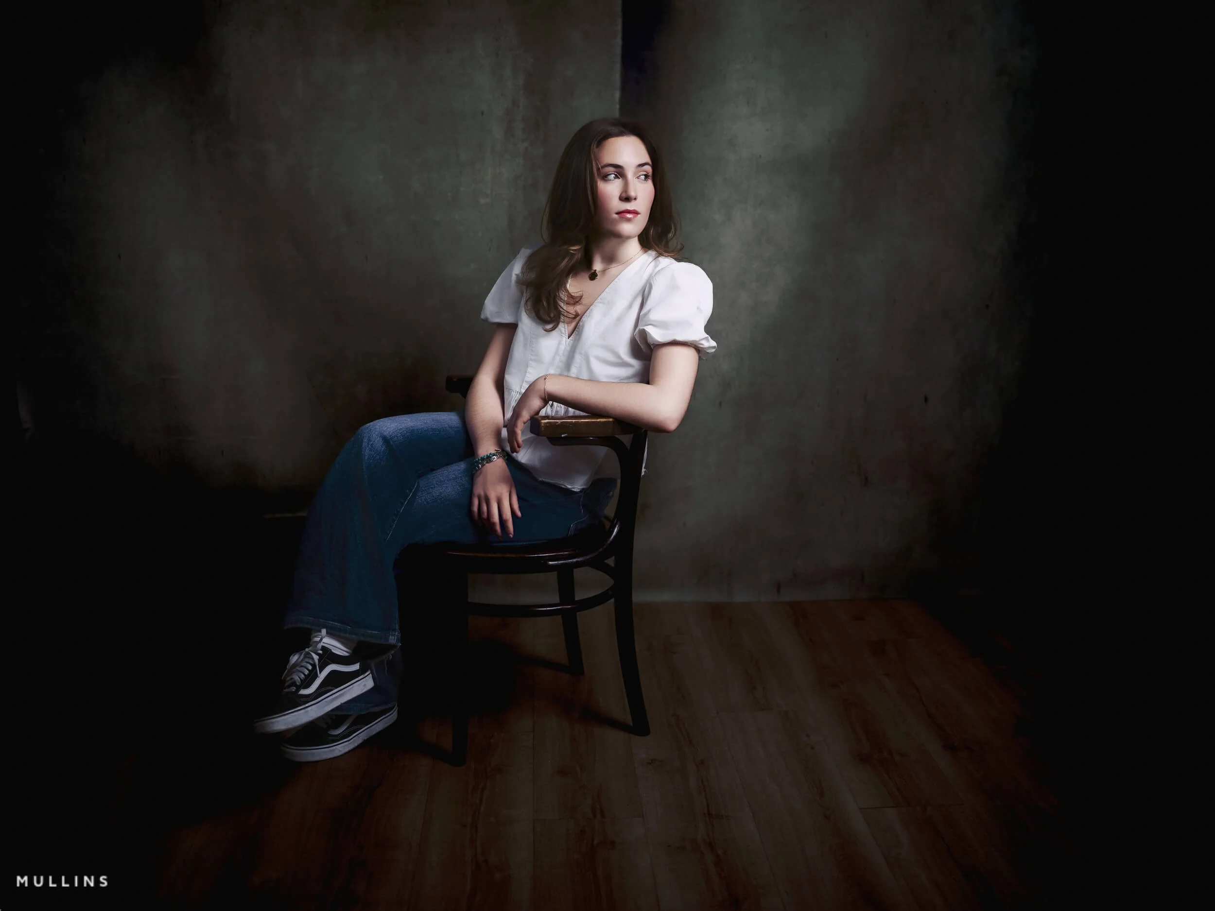 Seated actor portfolio photo of a young actress in a white blouse and jeans on a wooden chair in the Malmesbury studio.