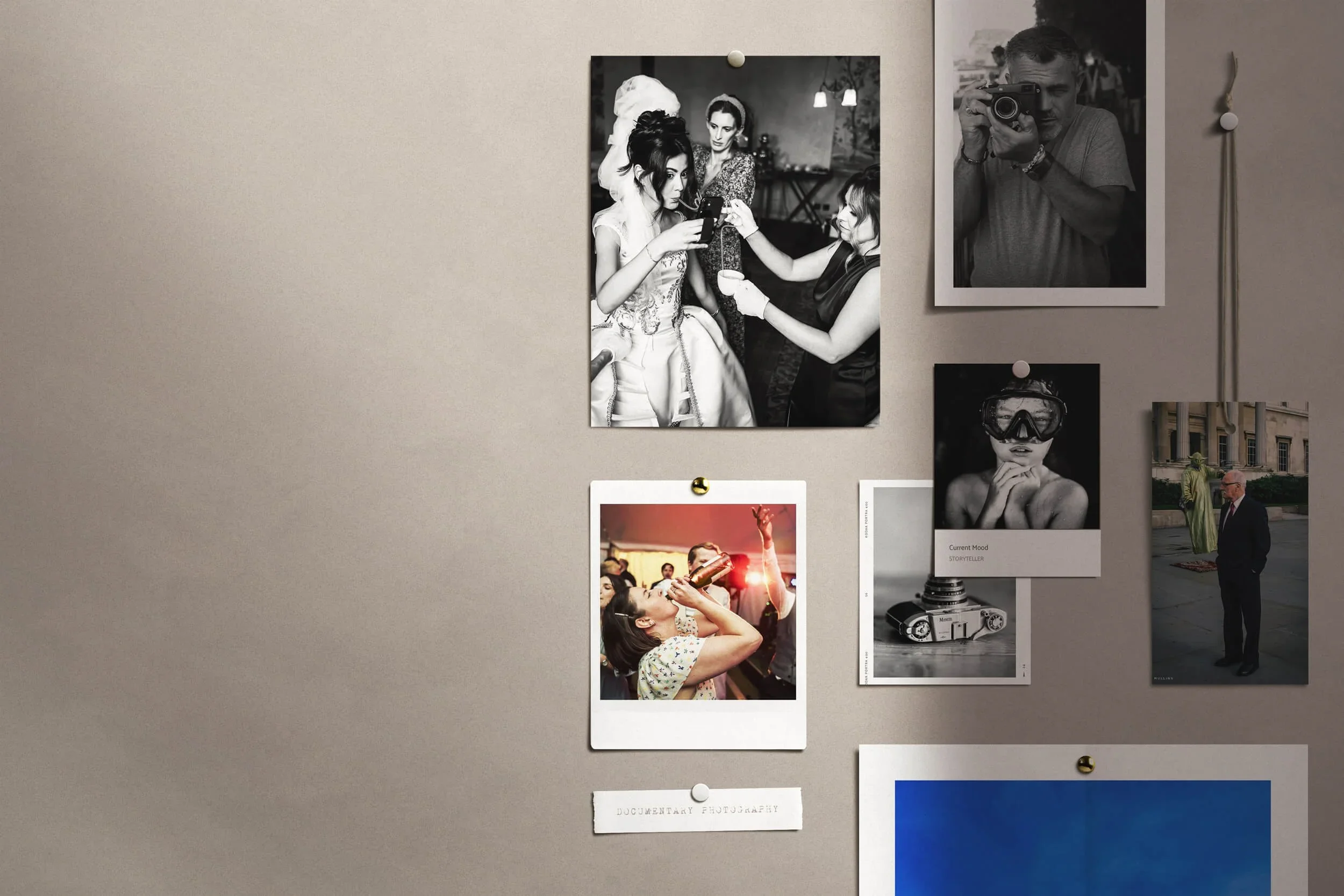 A collage of black and white and color photographs featuring people at social events, a woman getting her makeup done, a man taking photos, and a vintage camera, arranged on a wall with pins.