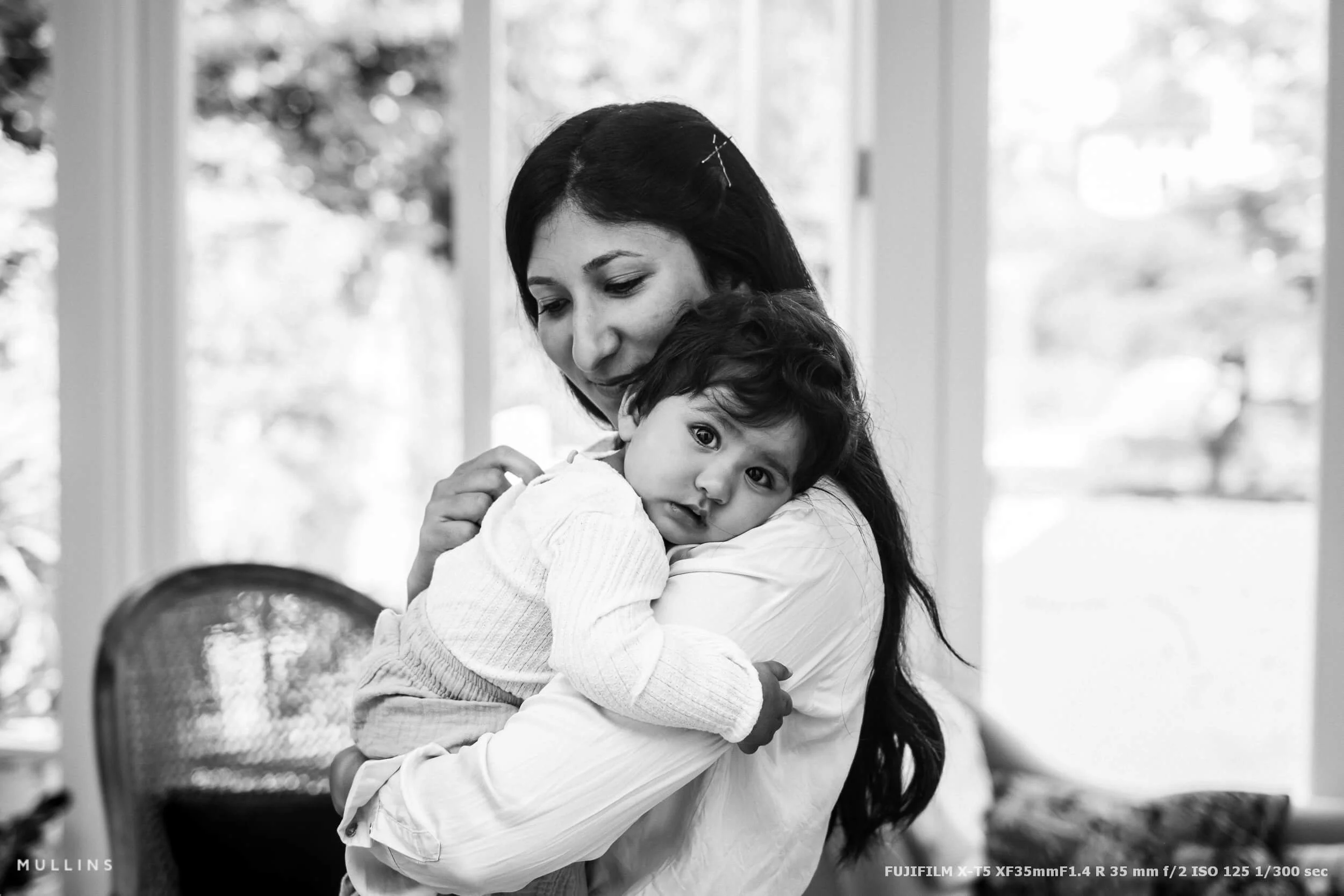 A mother holds her young child.
