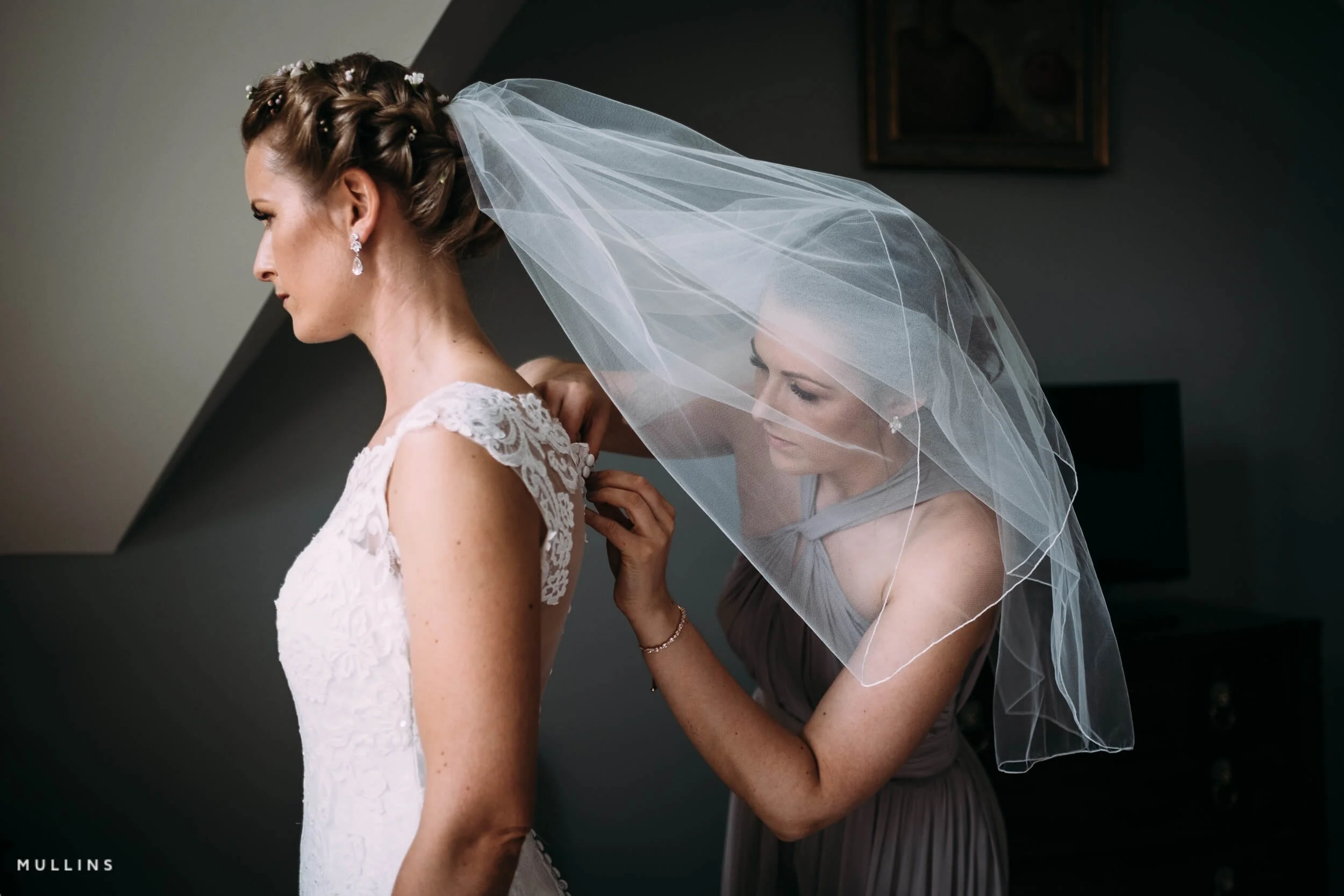 Bridesmaid helping a bride get ready