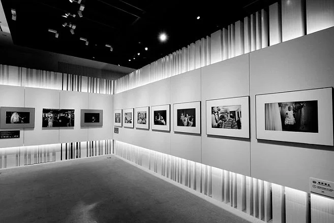 Black and white exhibition space showing Kevin Mullins wedding photographs on display